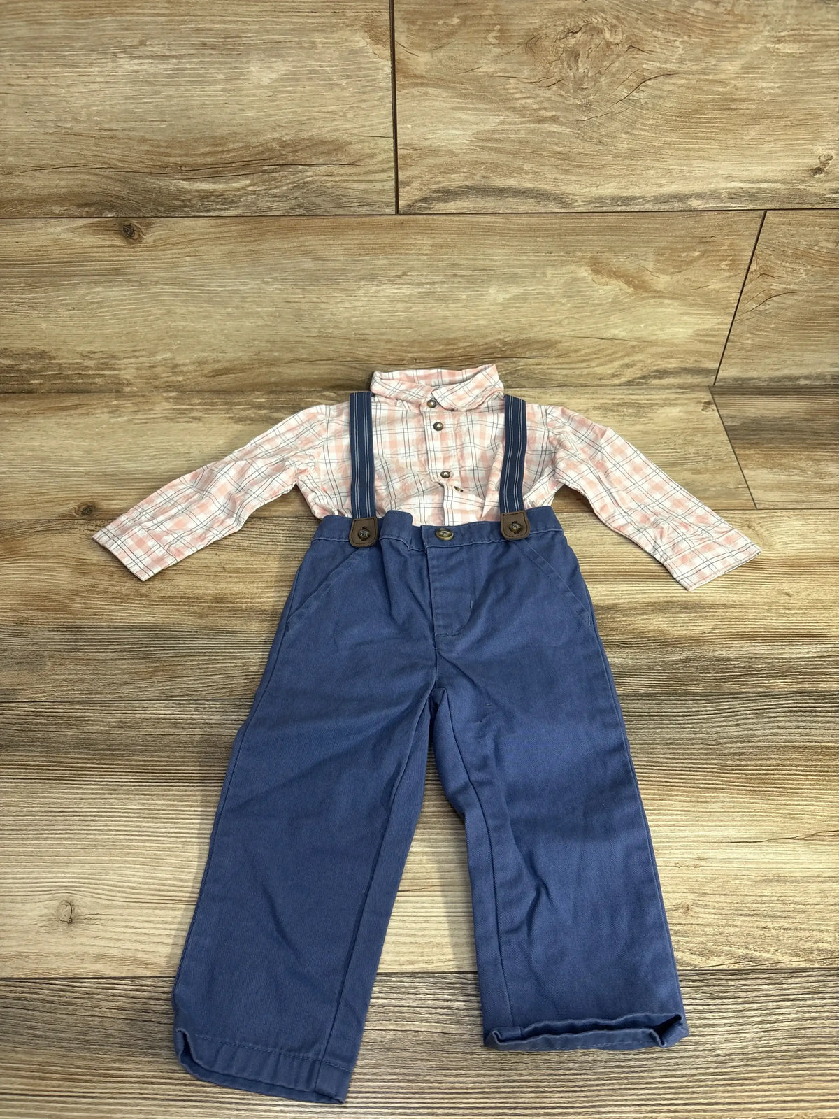 Plaid long sleeve shirt with blue suspender pants for toddlers on wooden background