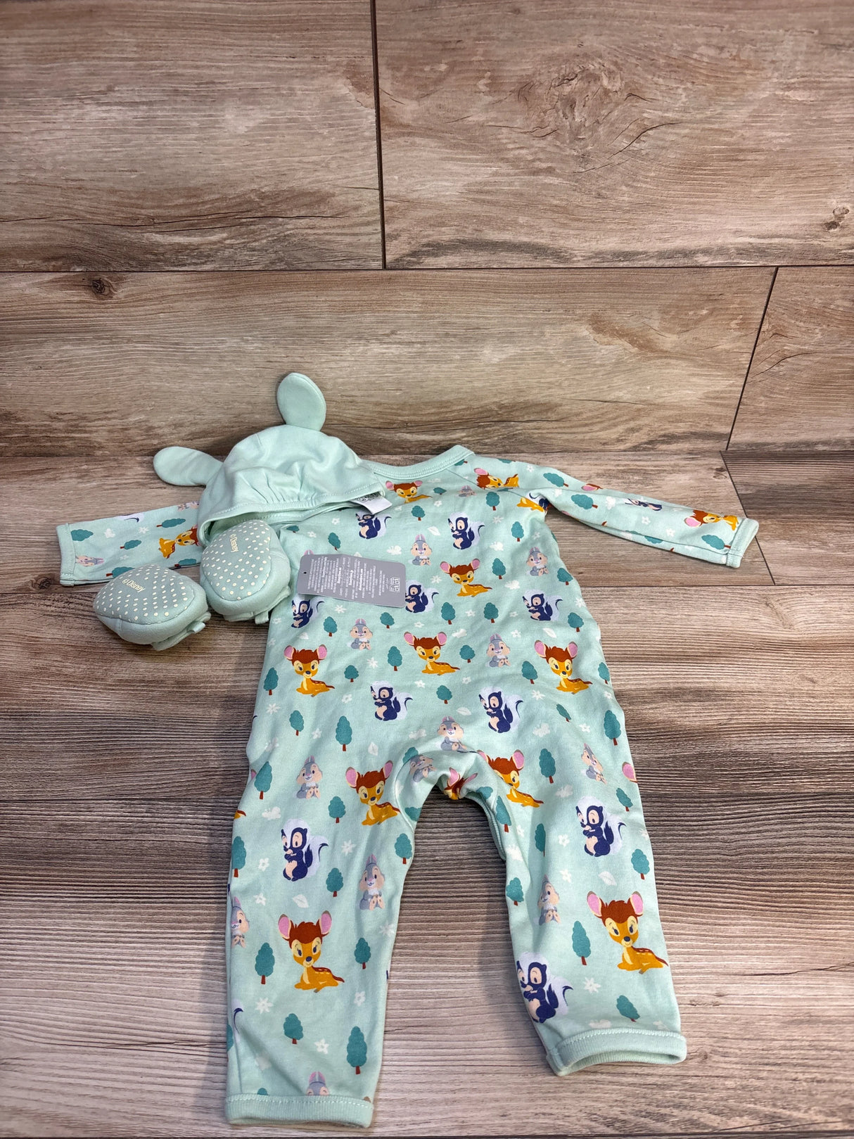 Baby romper set with deer print, mint hat with ears, and matching booties on wood floor