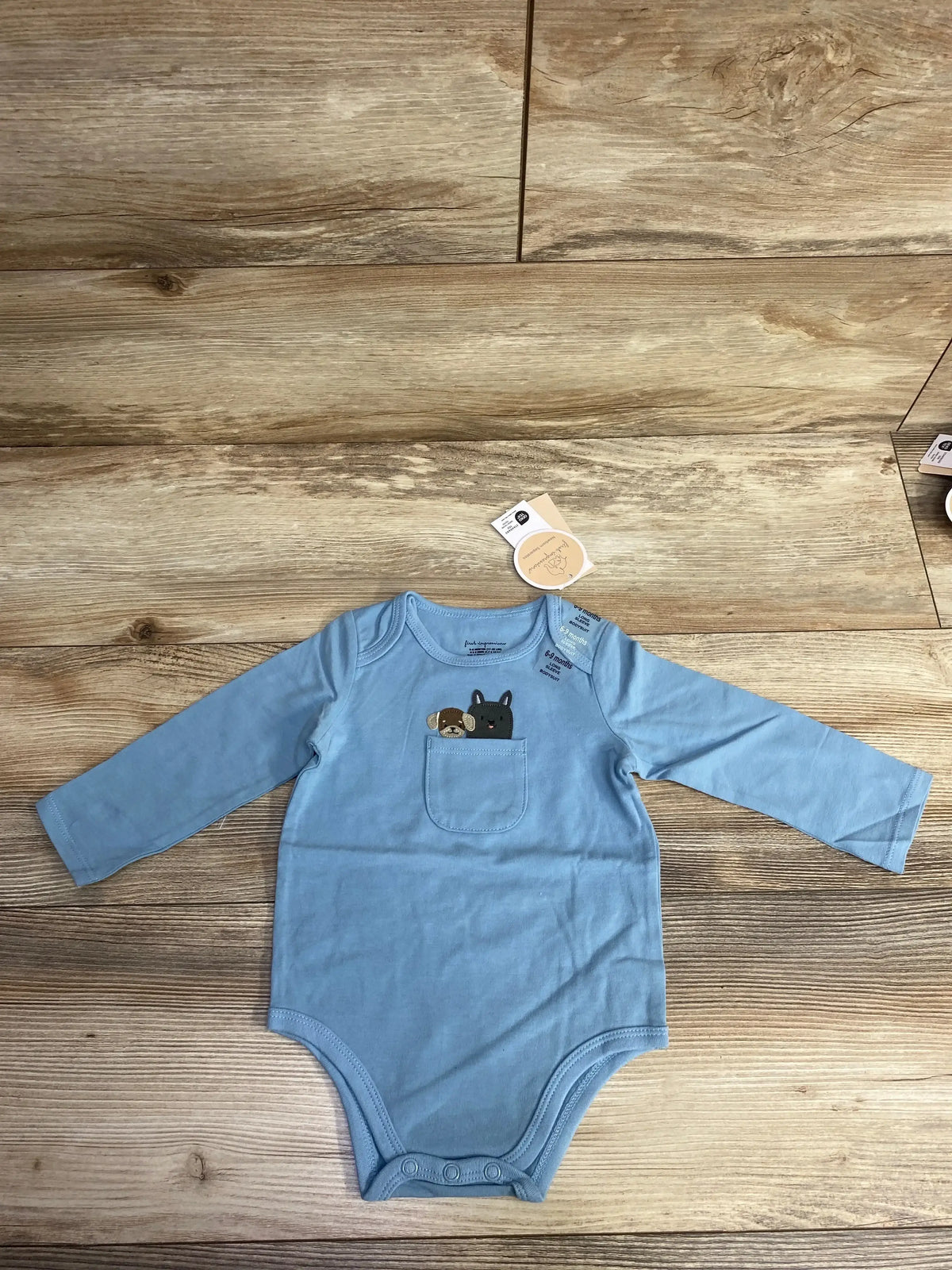 Blue long-sleeve baby onesie with small chest pocket featuring embroidered dog designs