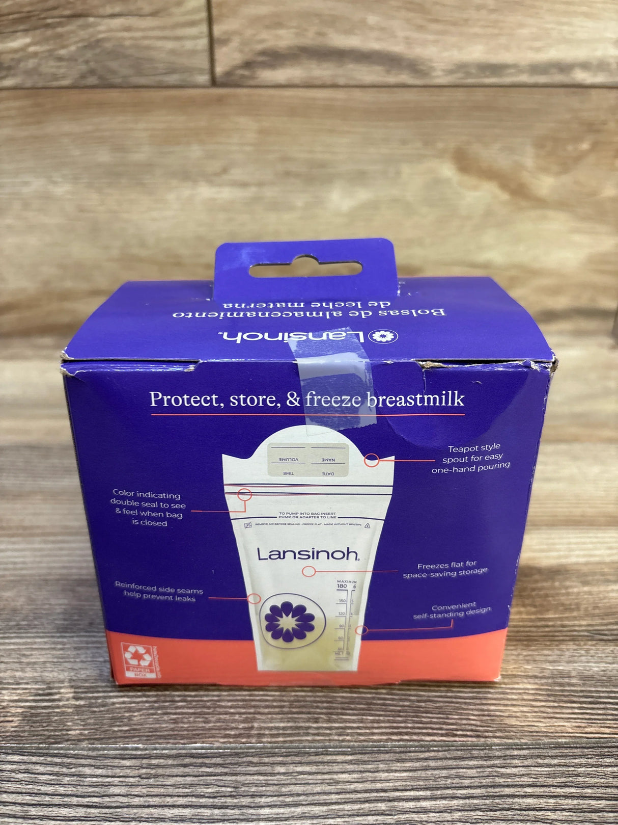 Front view of Lansinoh box of 6 oz breastmilk storage bags showing bag illustration and measurement markings on wooden table
