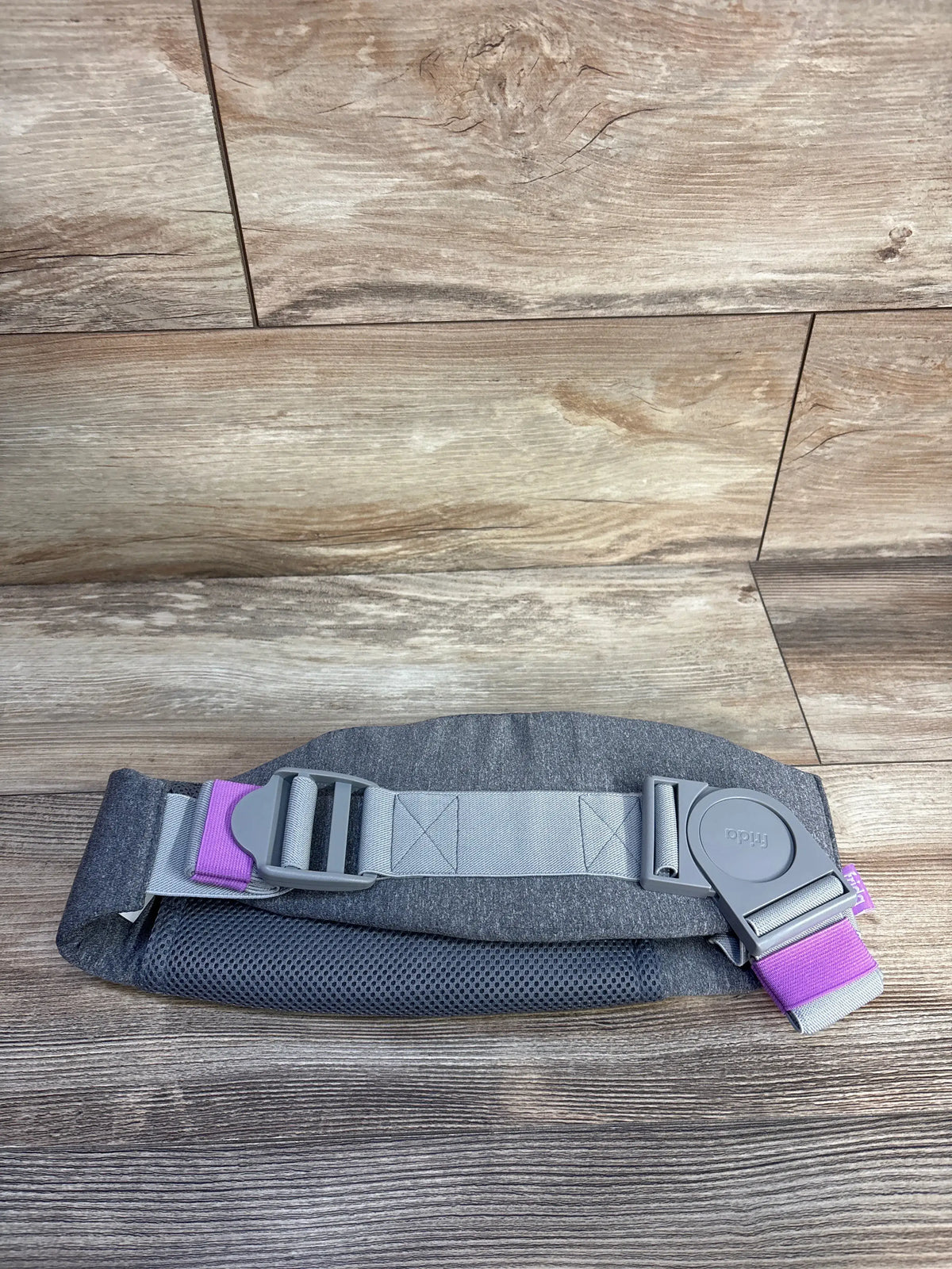 Top view of Frida Mom C Section Recovery Band in grey showcasing adjustable buckles and dual-layer design on wood flooring