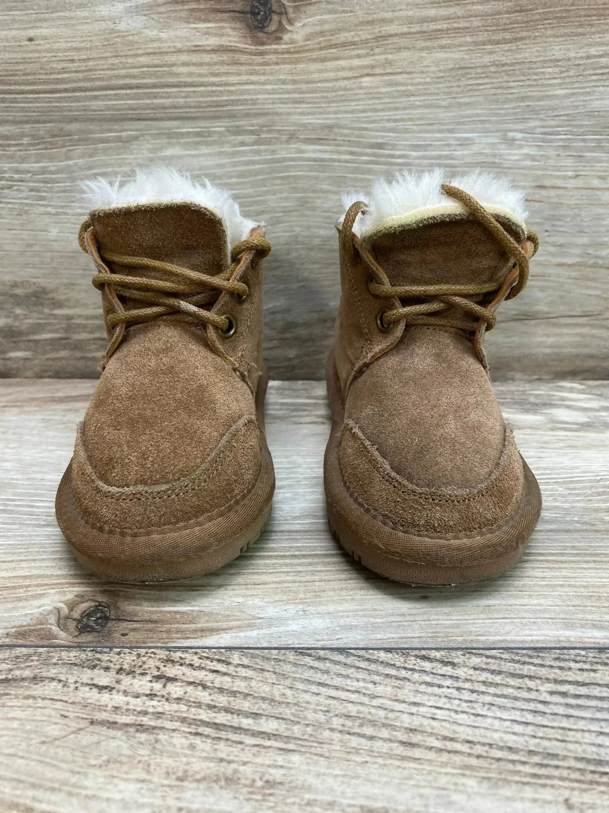 Front view of Lamo Chukka suede toddler boots in chestnut showing faux fur lining and laces on wood background, size 7C