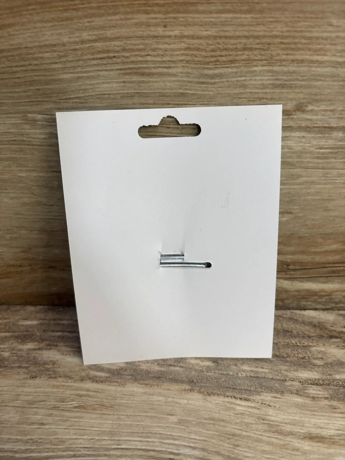 Back view of donut applique layered glitter hair bow display card showing attached silver hair clip on wood surface