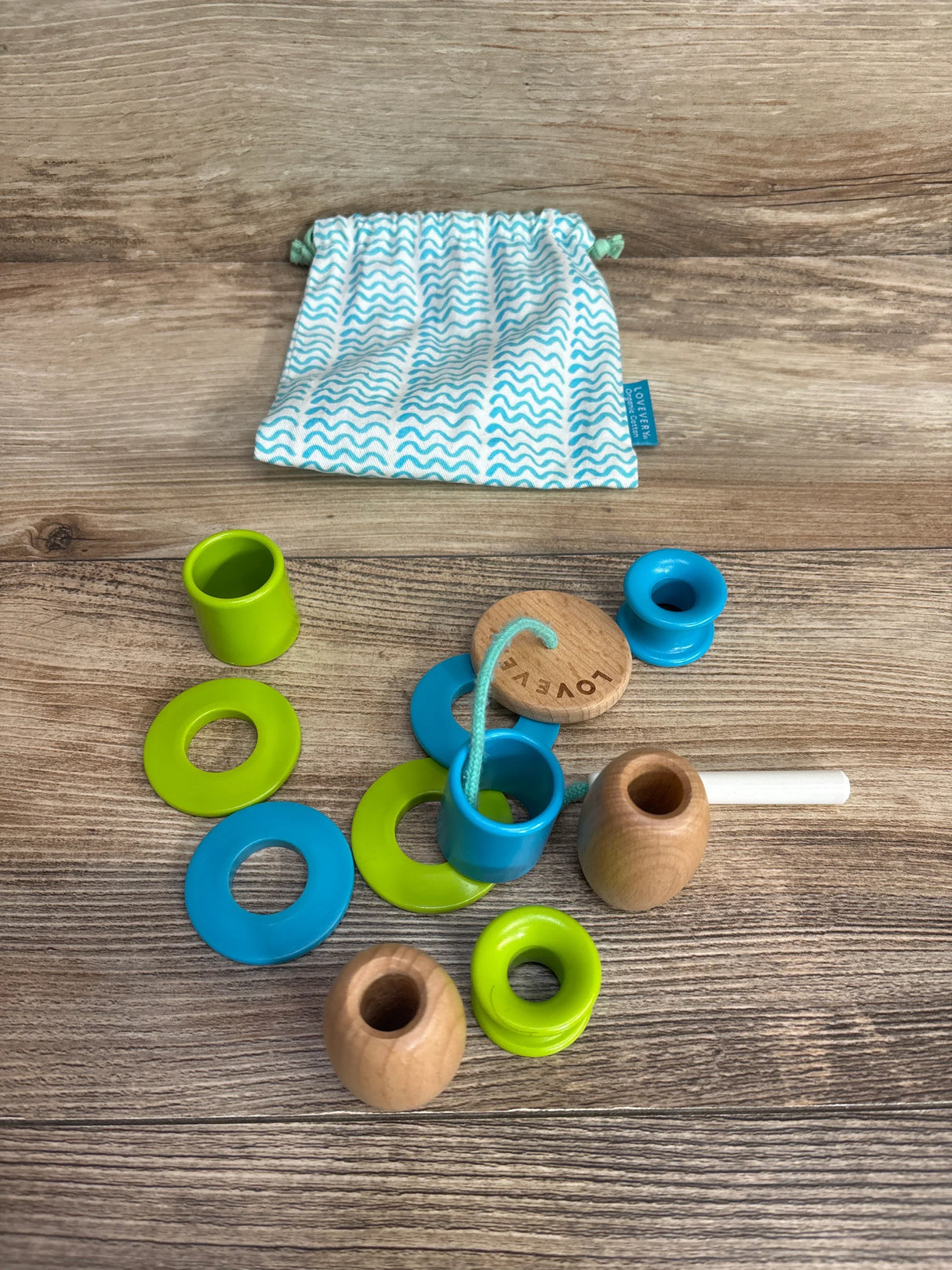 Wooden lacing toy with blue and green rings, drawstring bag, kids educational activity