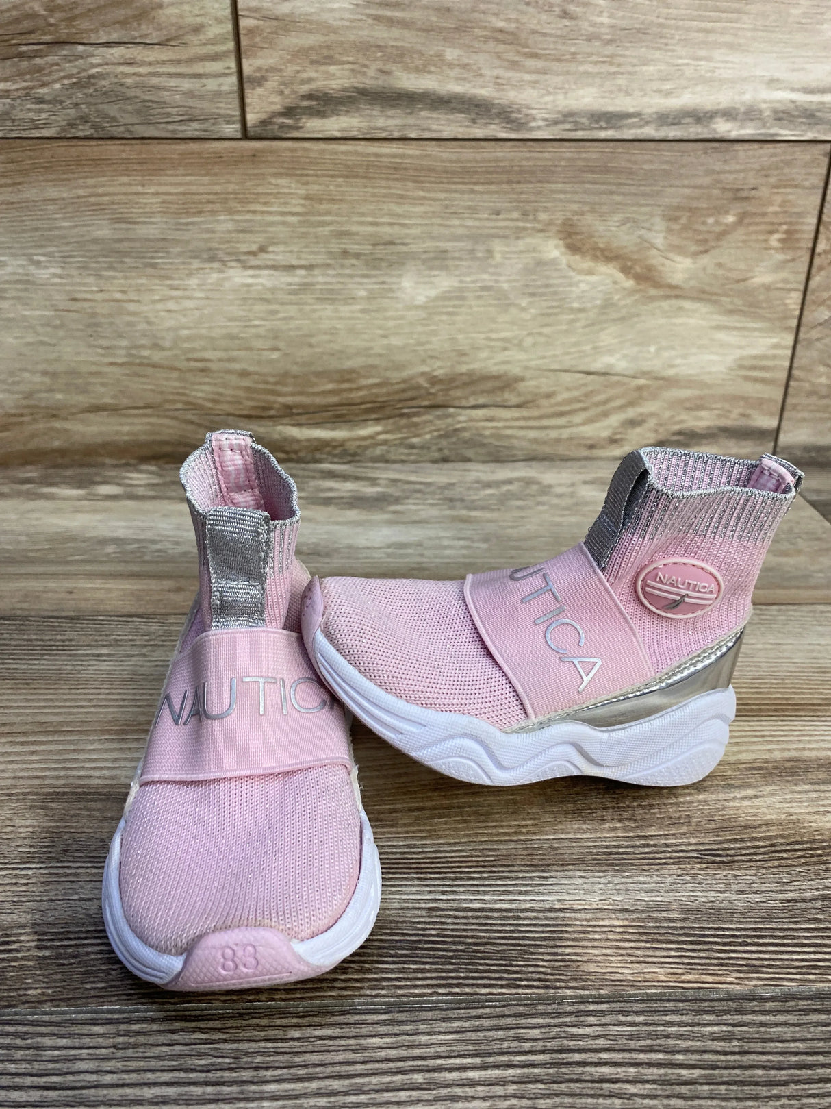 Three-quarter view of Nautica slip-on sock-style sneakers showcasing stretchy knit upper and white sole on white background