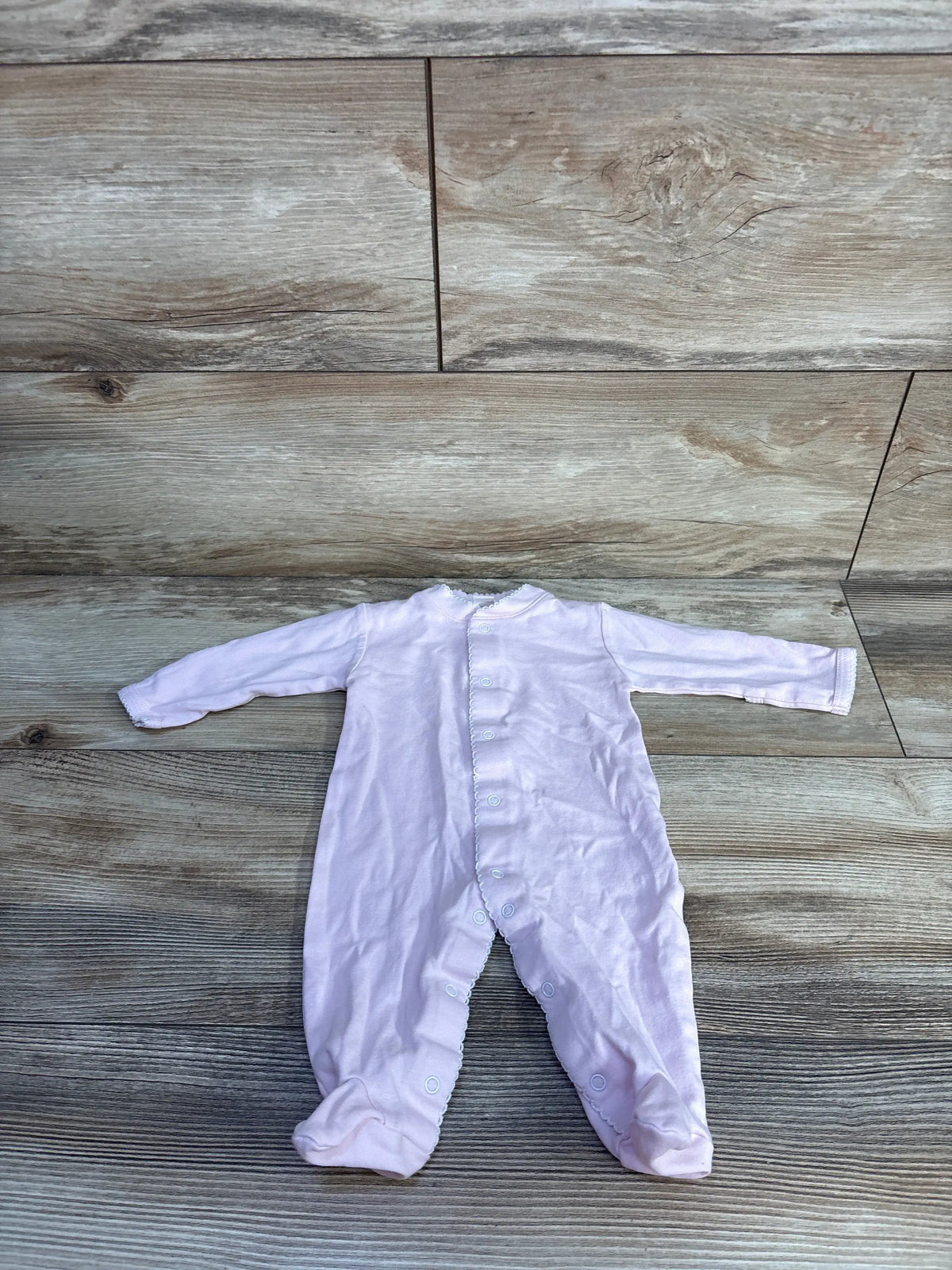Front view of Kissy Kissy snap sleeper showcasing soft pink Pima cotton and front and inseam snaps on a wood floor