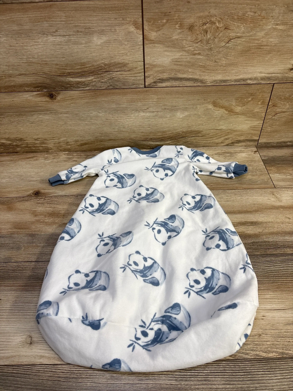 Front view of white sleep sack 0-3M with blue panda print, long cuffed sleeves and soft fleece on wood background
