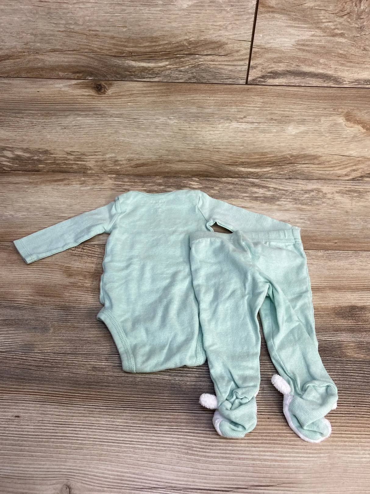Front view of green 2-piece baby bodysuit and pants showcasing Every Bunny Loves Me bunny graphic on the bodysuit with white background