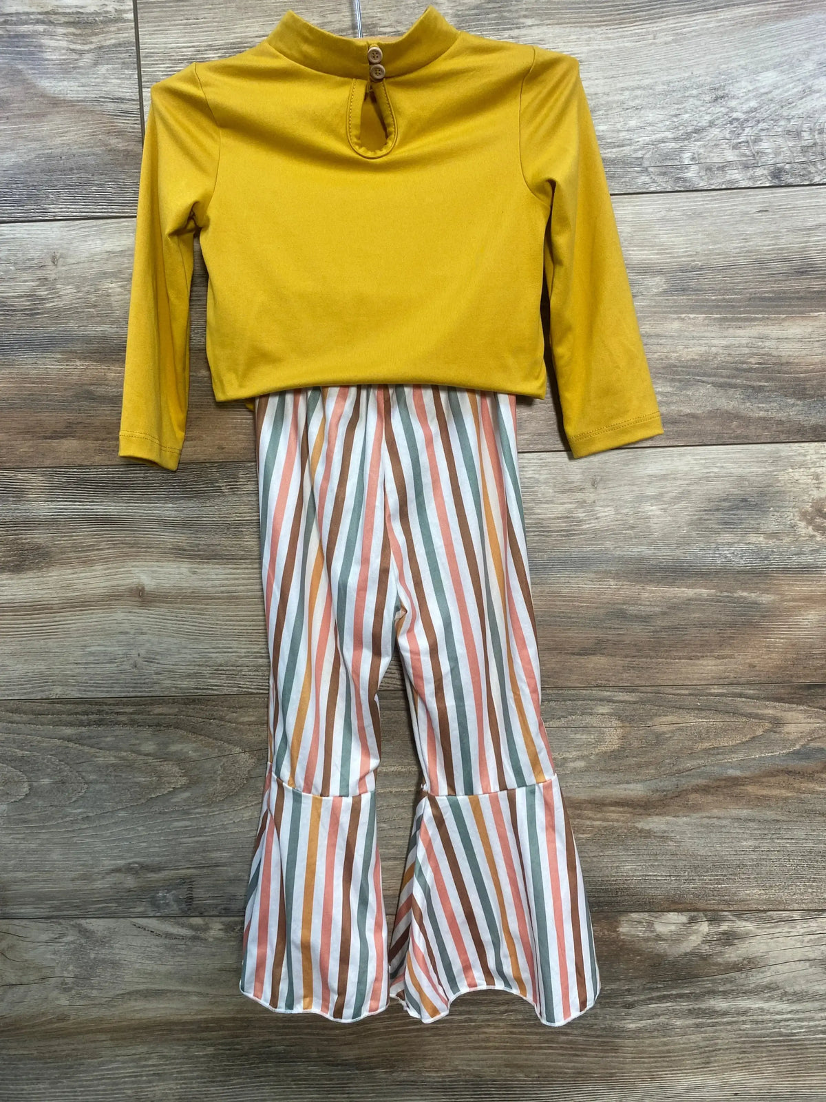 Mustard yellow long-sleeve top with keyhole button back paired with multicolor striped bell-bottom pants