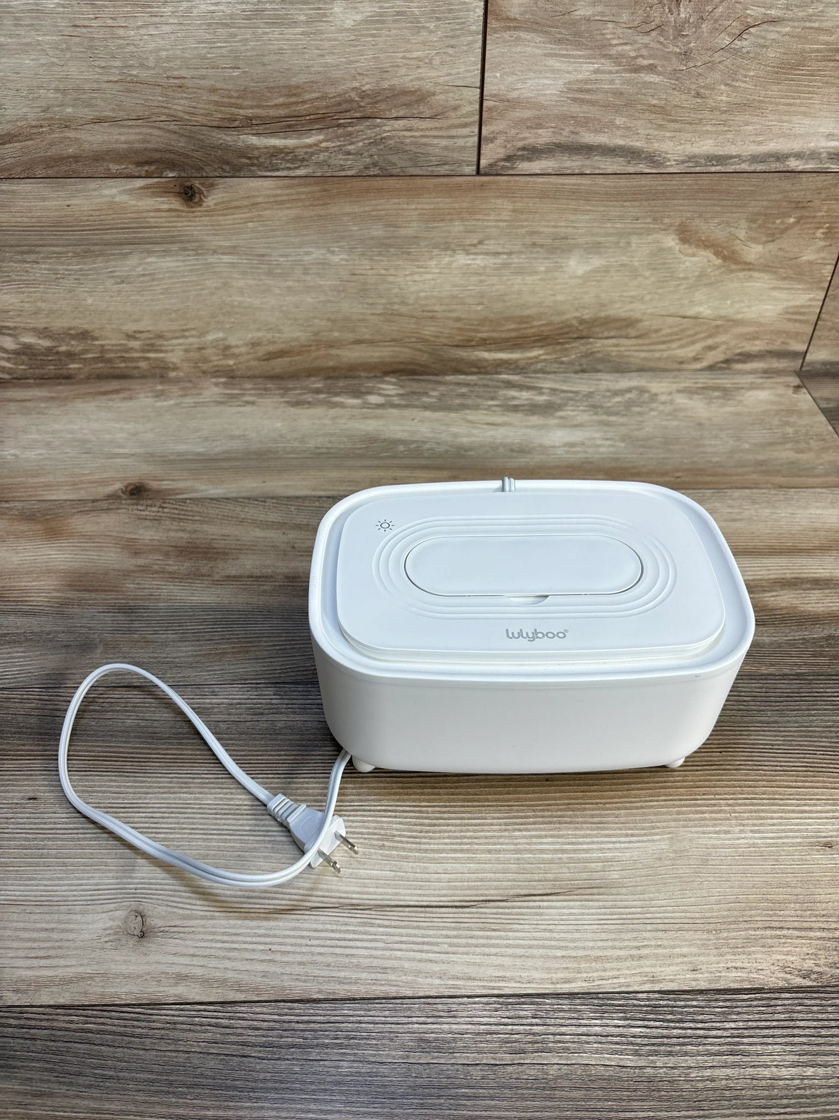 White Lulyboo baby wipe warmer on wooden surface with power cord