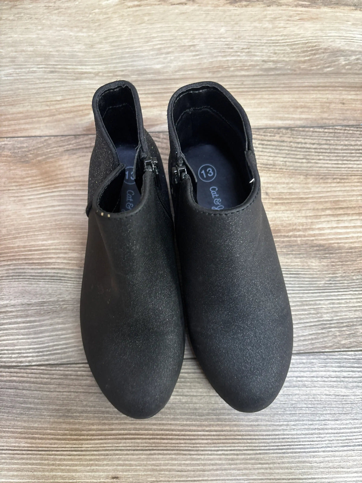 Black kids ankle boots, size 13, with side zippers on wood floor.