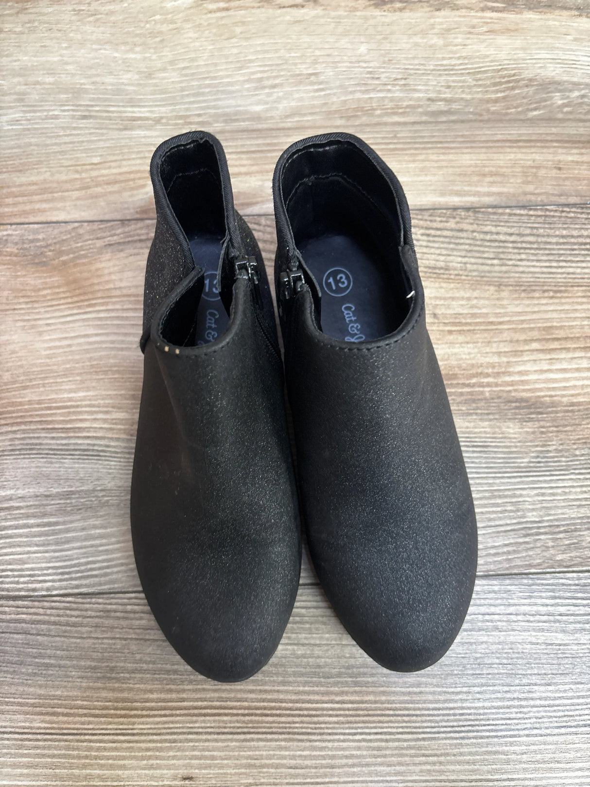 Black kids ankle boots, size 13, with side zippers on wood floor.