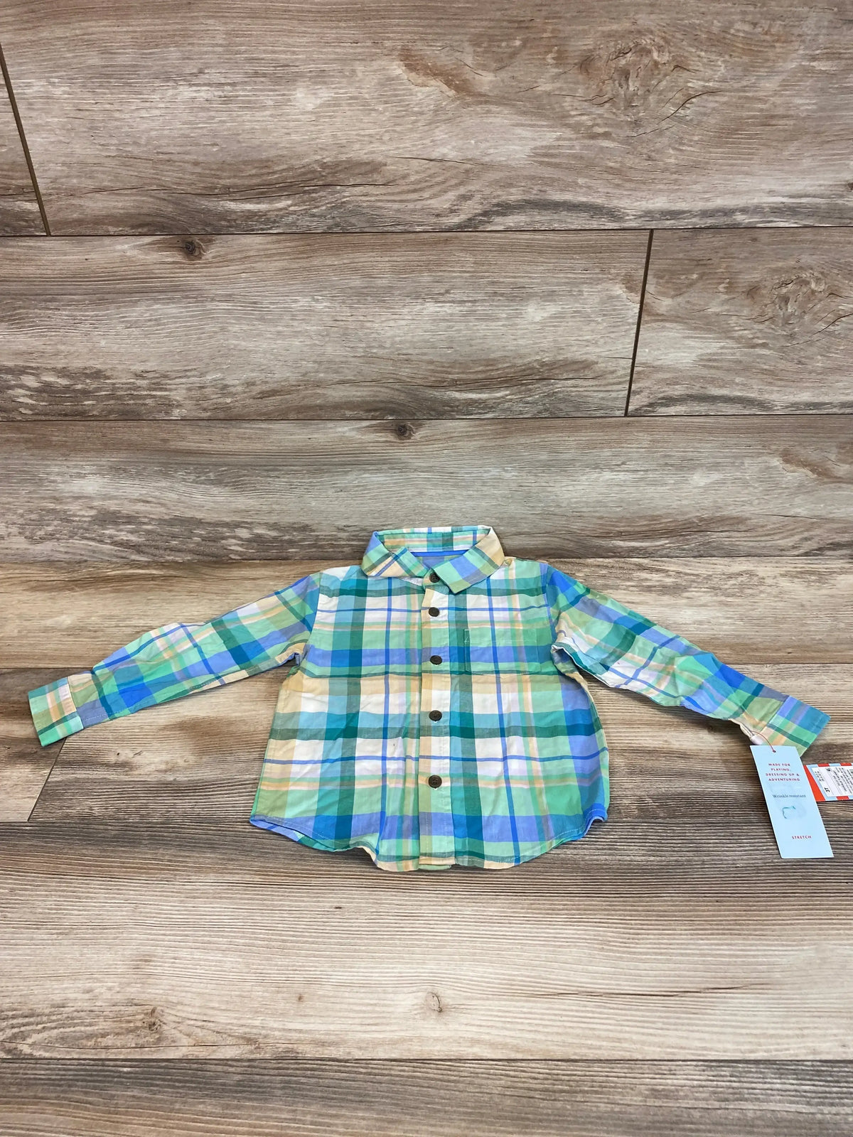 Flat lay of NEW Cat & Jack Plaid Button-Up Shirt size 3T showcasing green blue and yellow plaid long-sleeve shirt with hangtag on wood plank floor