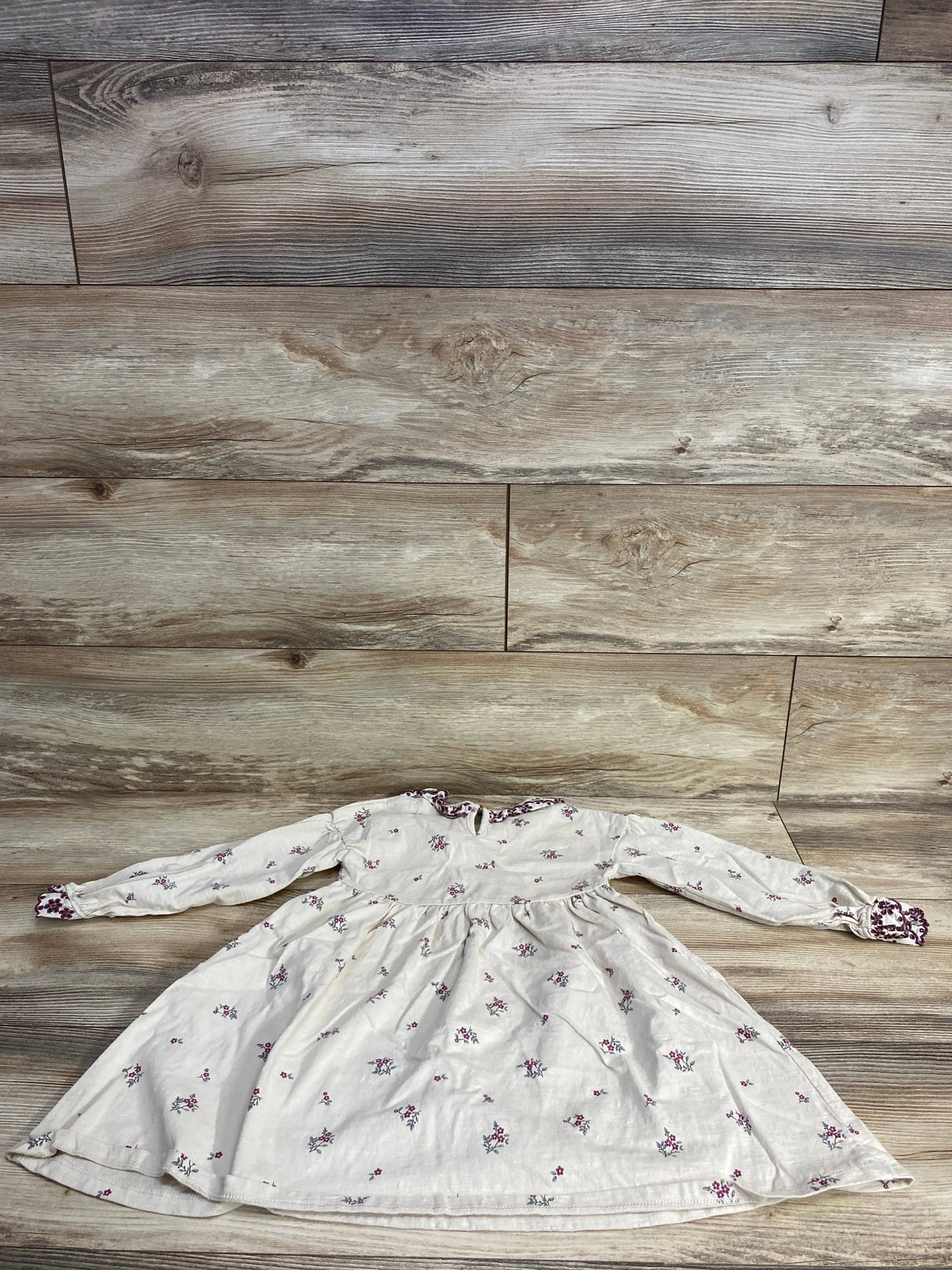White long-sleeve toddler dress with purple floral print and purple trim on cuffs and collar