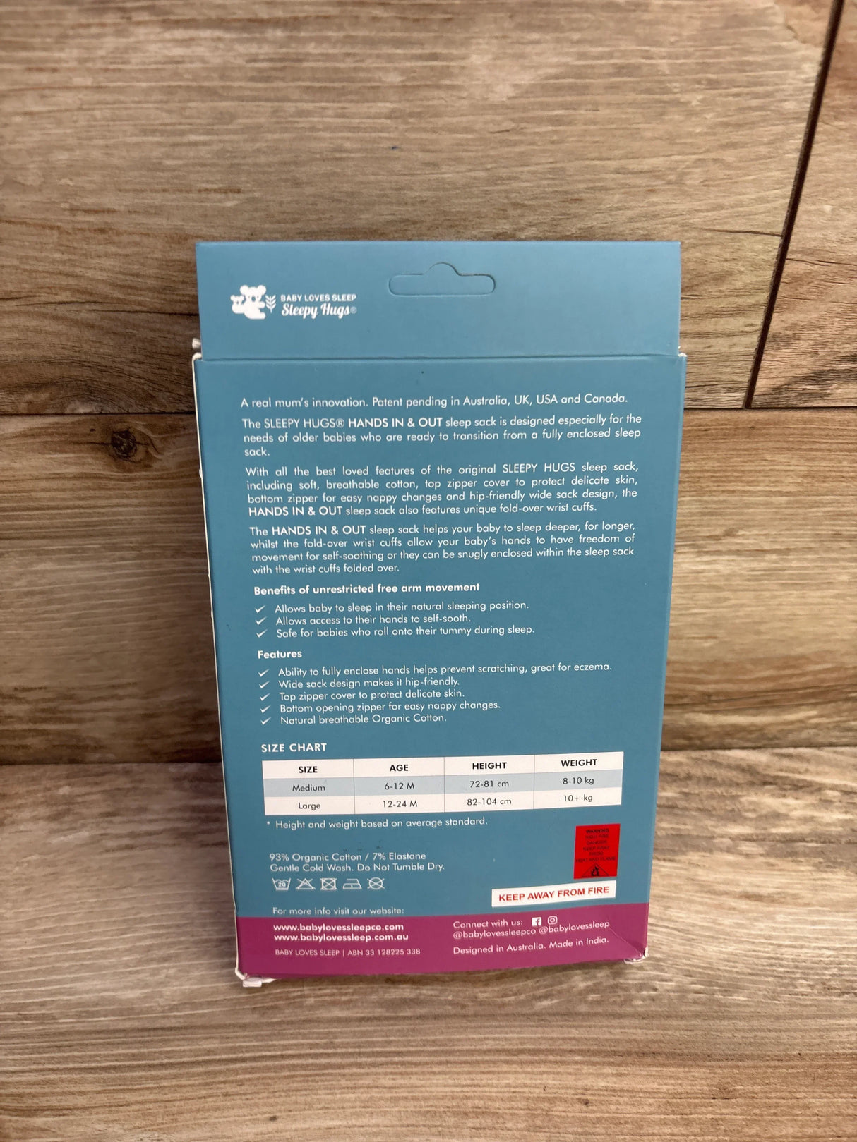 Back of Sleepy Hugs Hands In & Out sleep sack box with size chart and product details on wood surface.