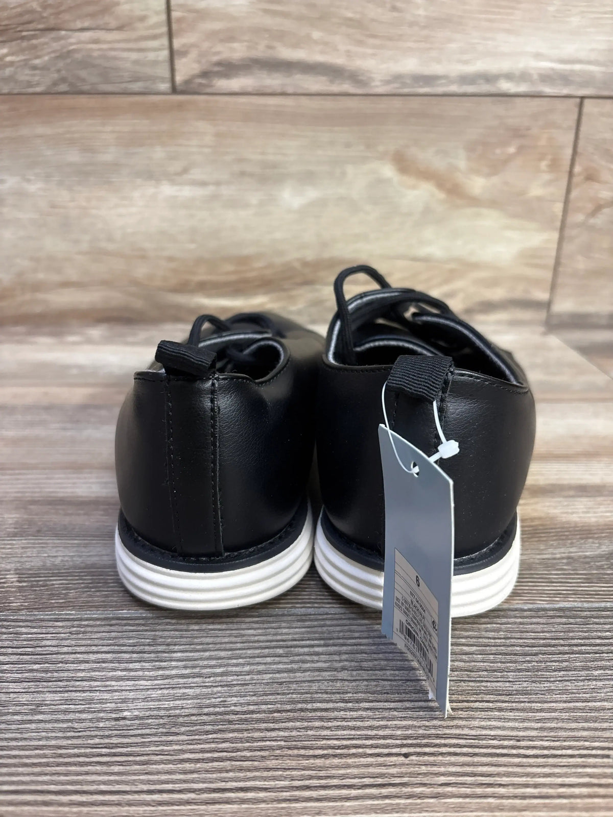 Rear view of NEW Cat & Jack Alfi dress shoes in black, size 6Y, showcasing lace closures with white soles on a wood floor