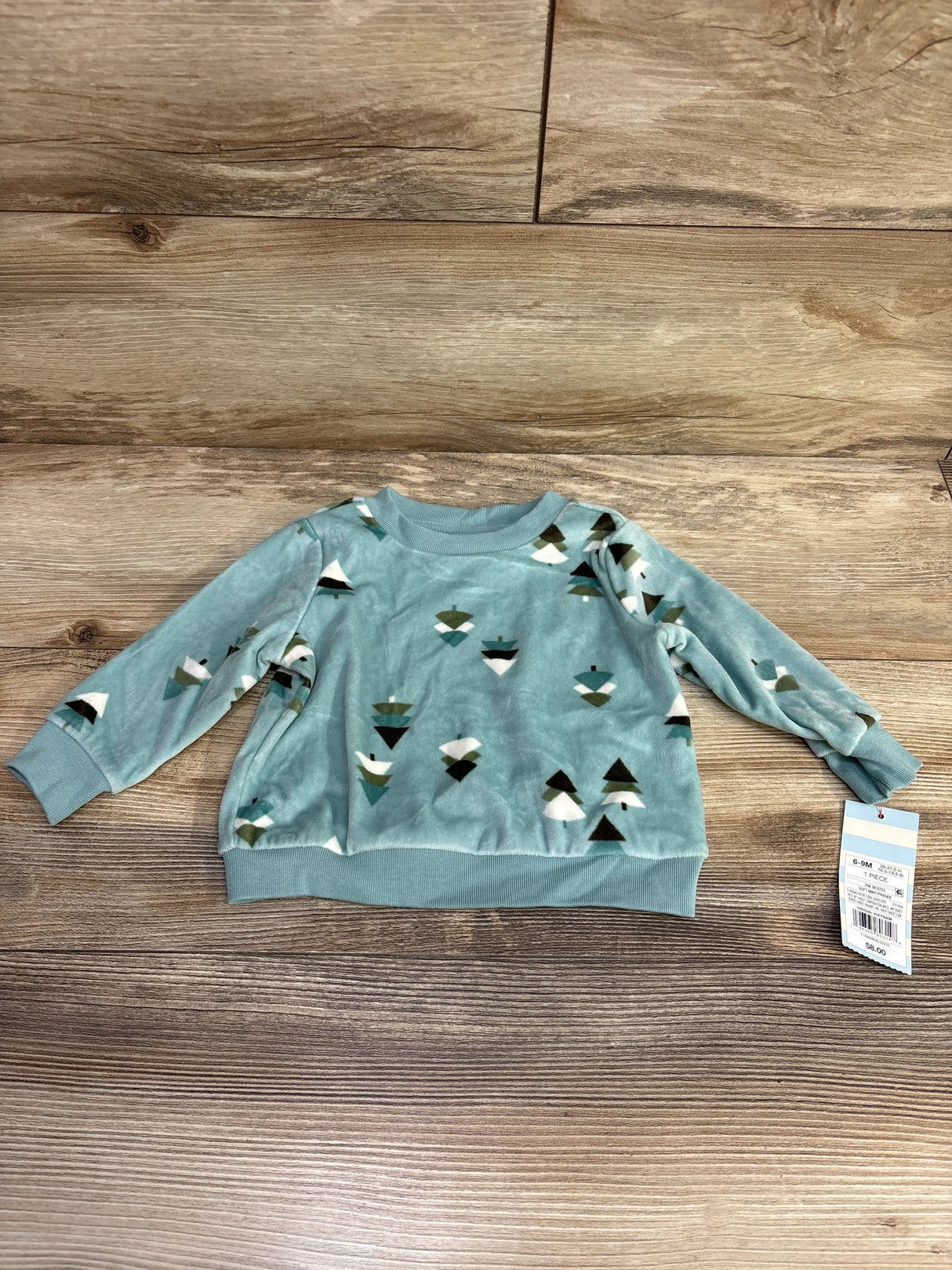 Light blue toddler sweatshirt with abstract tree pattern, size 6-9M, on wood background