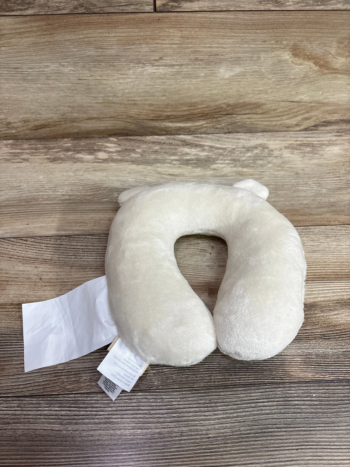 Top view of Pooh Bear Collection travel neck pillow showcasing a plush cream U-shaped design on a wooden surface