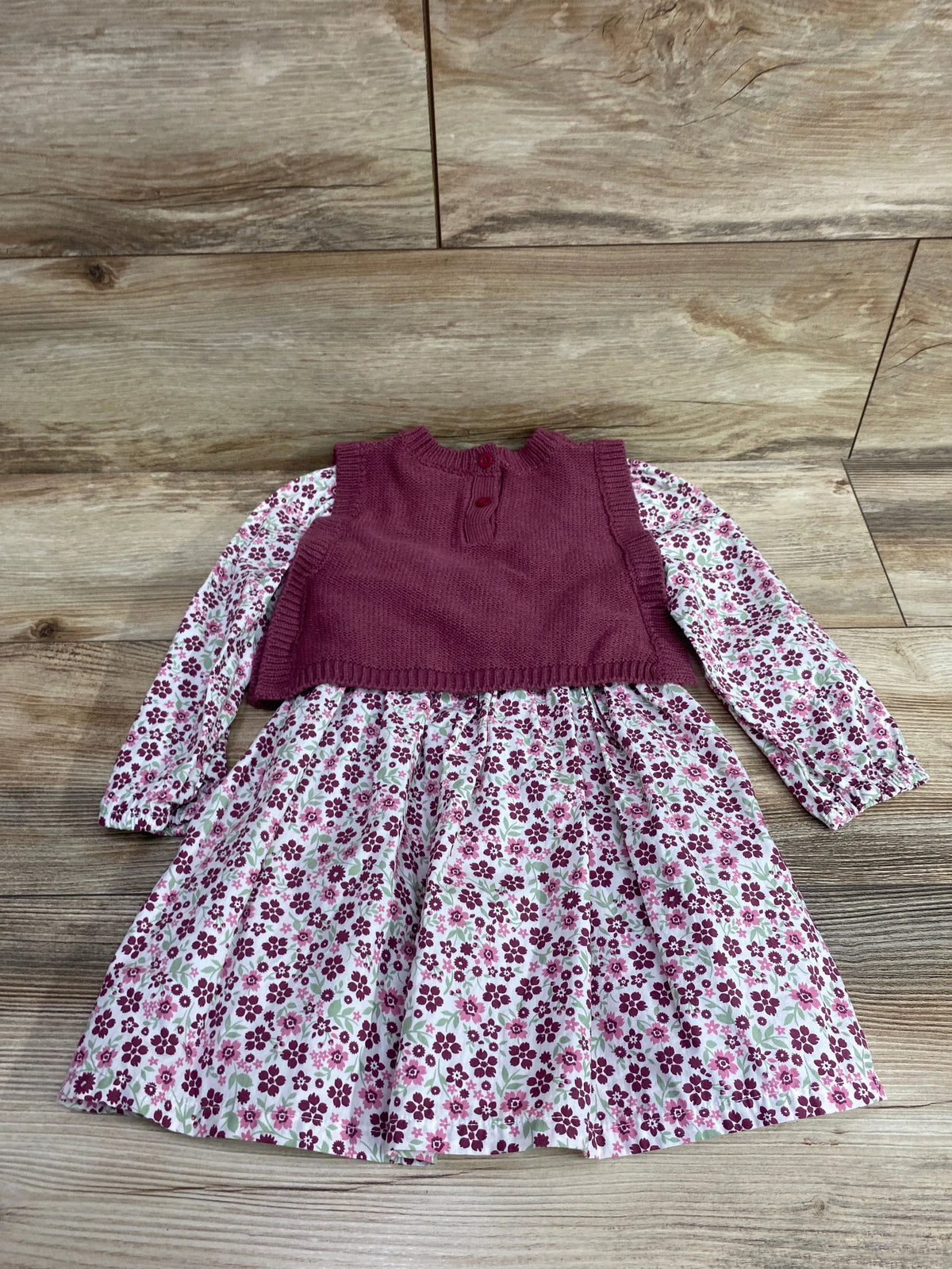 Front view of Nicole Miller 2-piece floral long-sleeve dress and knit vest in pink, size 2T, on a wood background