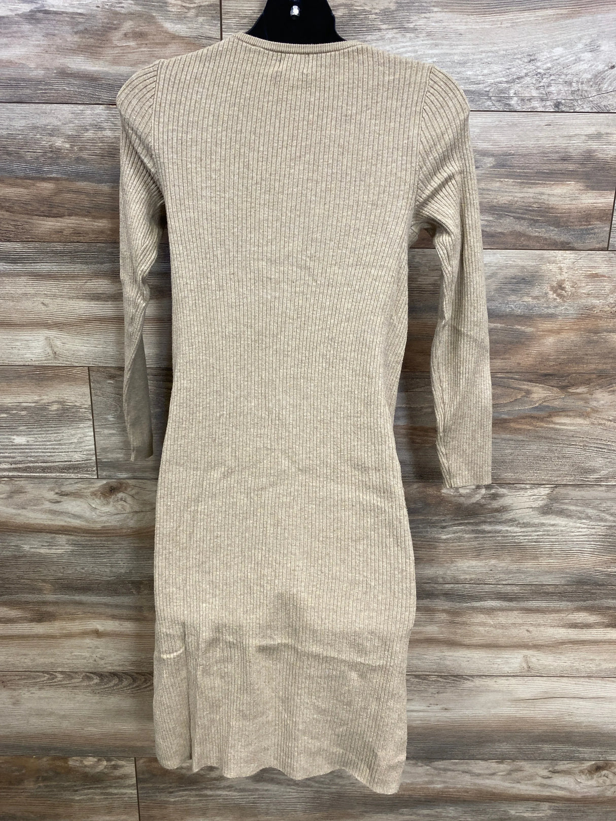 Back view of Isabel maternity ribbed sweater-knit bodycon dress in tan showcasing long sleeves and ribbed texture on wood background