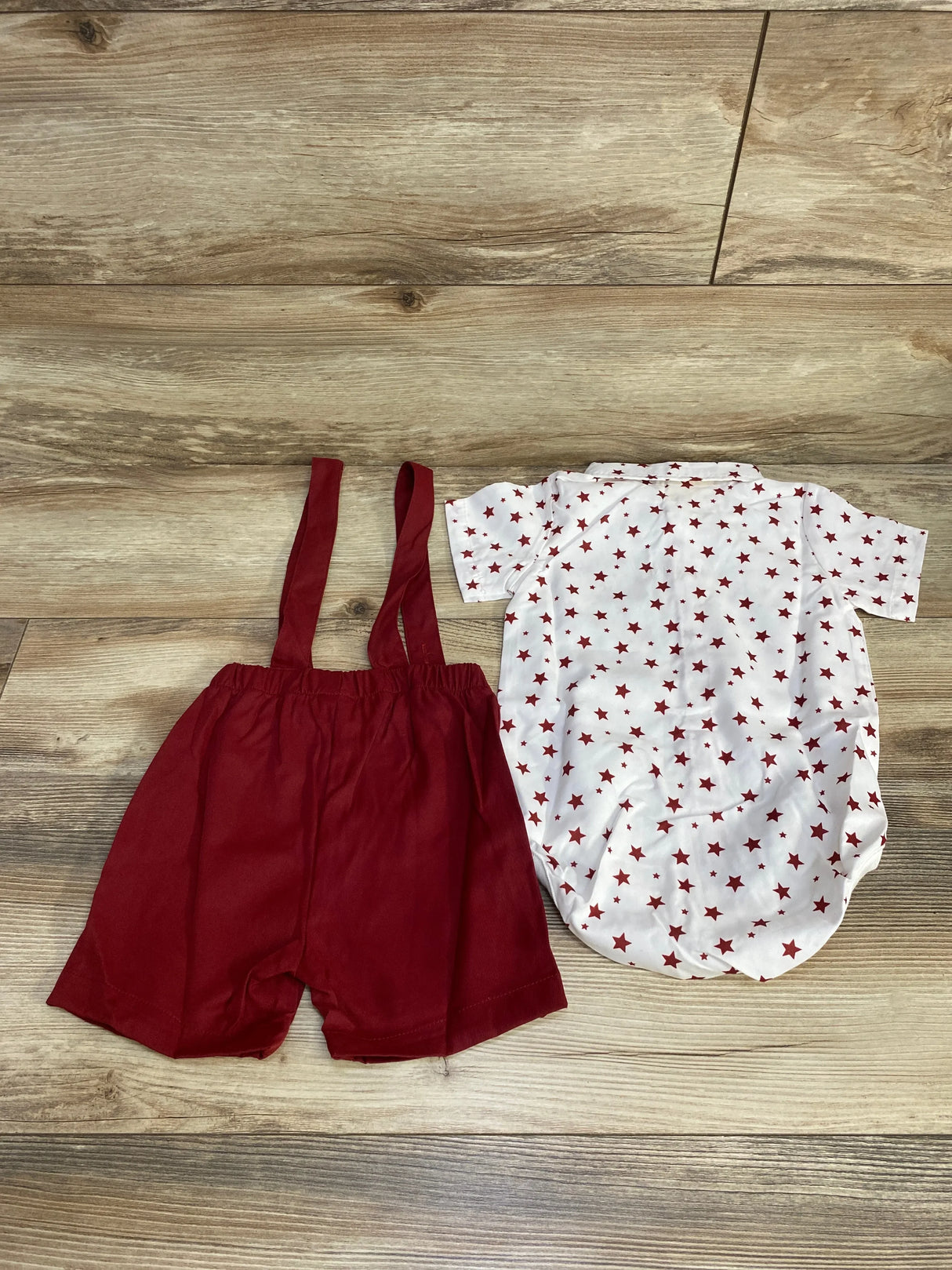 Red toddler suspender shorts and white shirt with red stars on wood floor