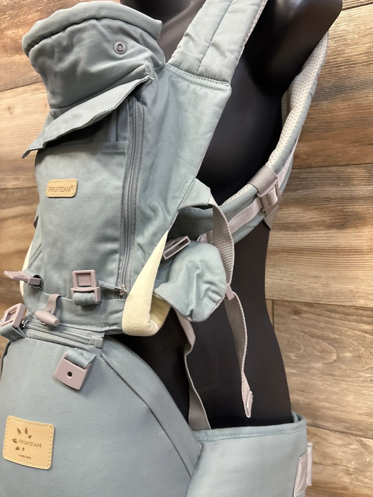 Close-up of a blue Me n Mommy To Be 6-in-1 baby carrier with hip seat on a mannequin.