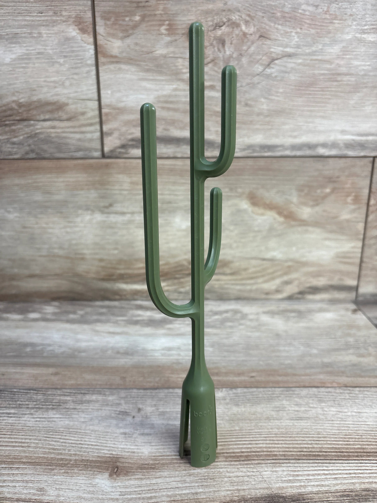 Front view of Boon Twig drying rack accessory in cactus green showing multiple upright branches and slotted base on wood background