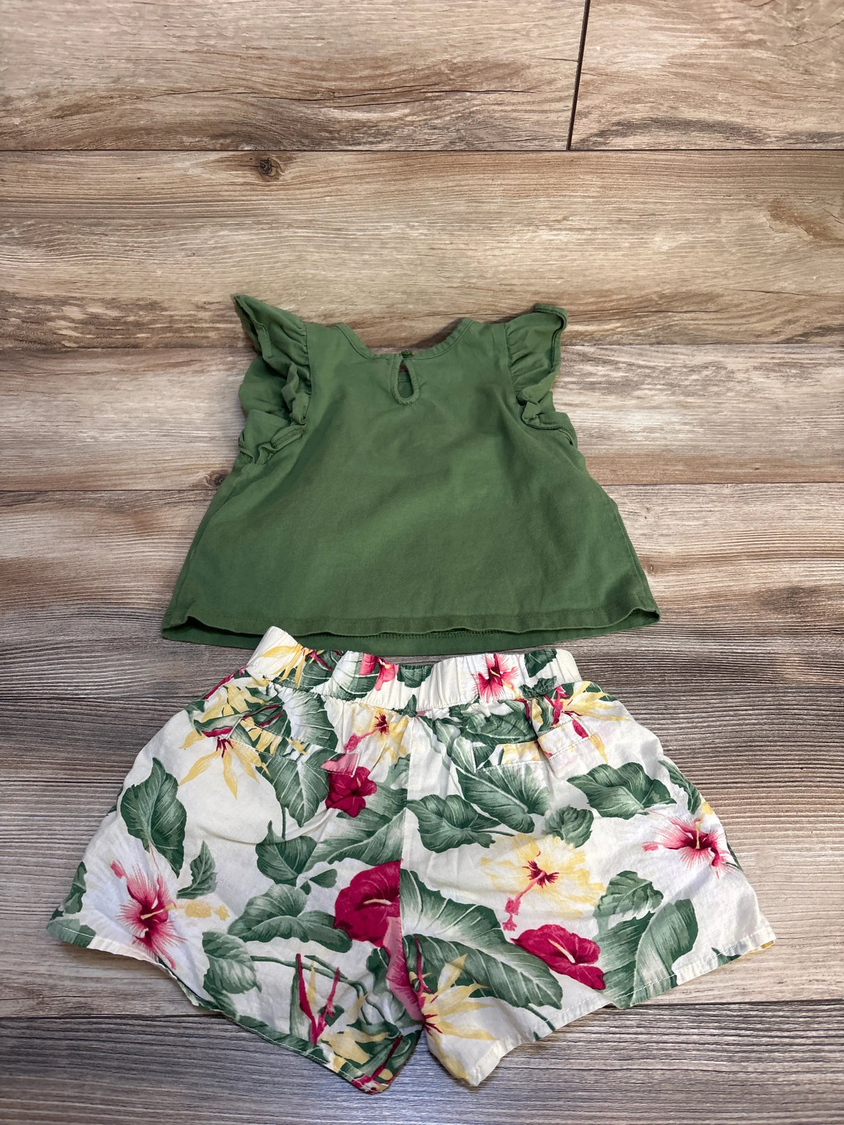 Girls' green ruffle sleeve top with floral print shorts on wood floor