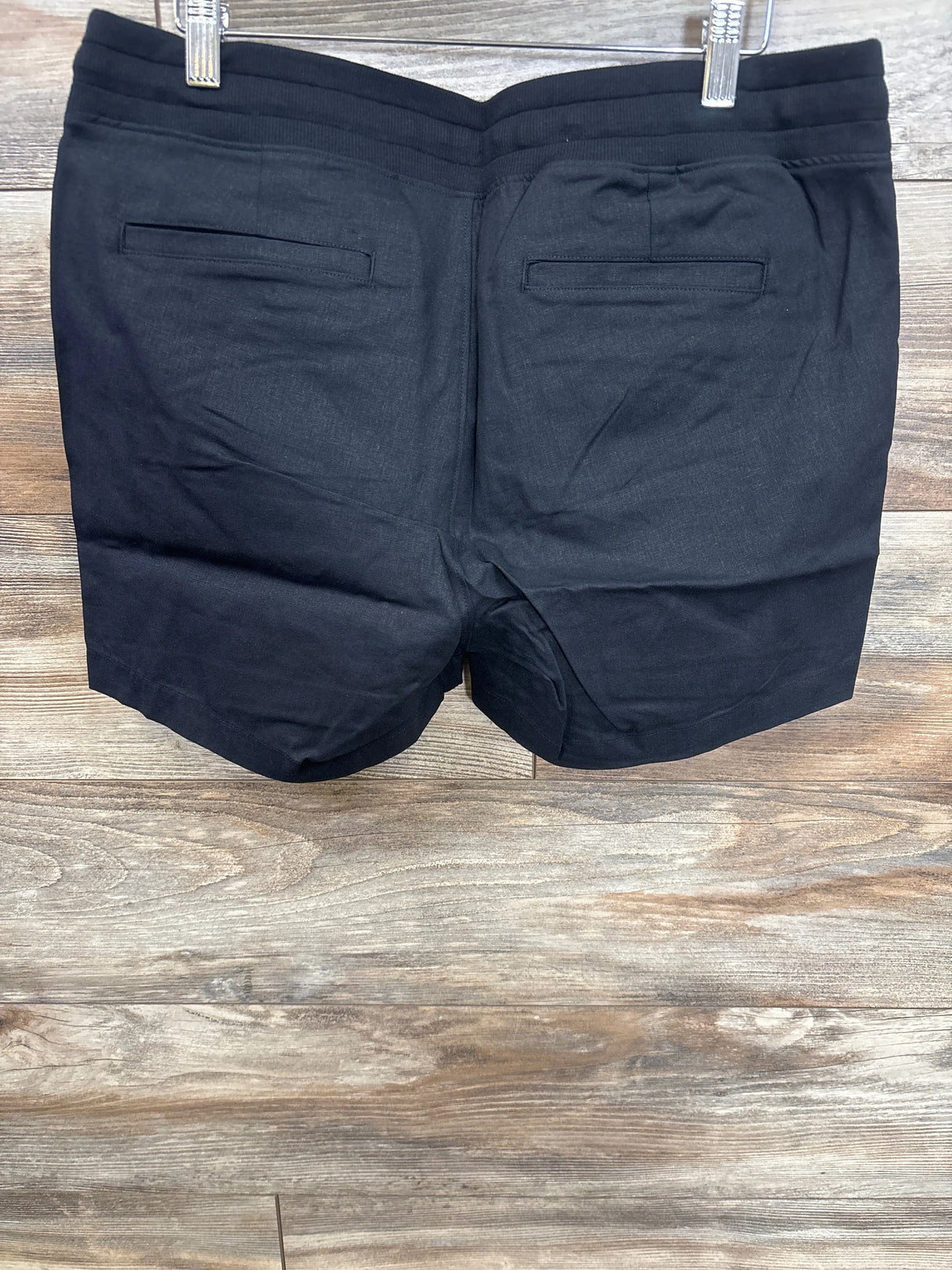 Black maternity shorts with back pockets, displayed on hanger for kids and maternity resale