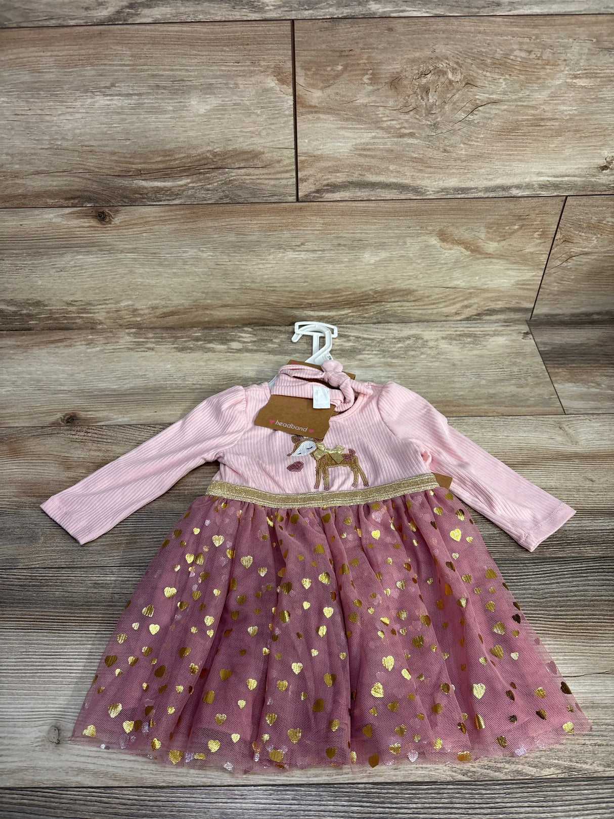 Pink long sleeve girls dress with gold heart tulle skirt and deer print bodice on wood floor