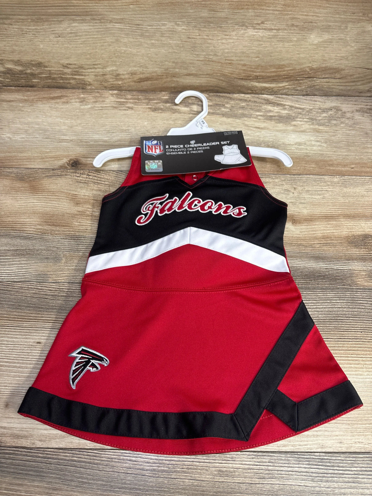 Red and black Atlanta Falcons NFL toddler cheerleader dress with team name and logo on wooden floor