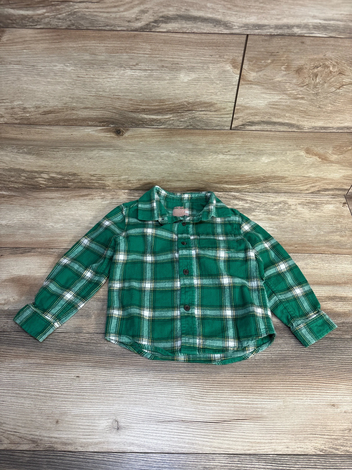Green plaid kids button-up shirt on wood floor, perfect for toddler or baby boy outfits