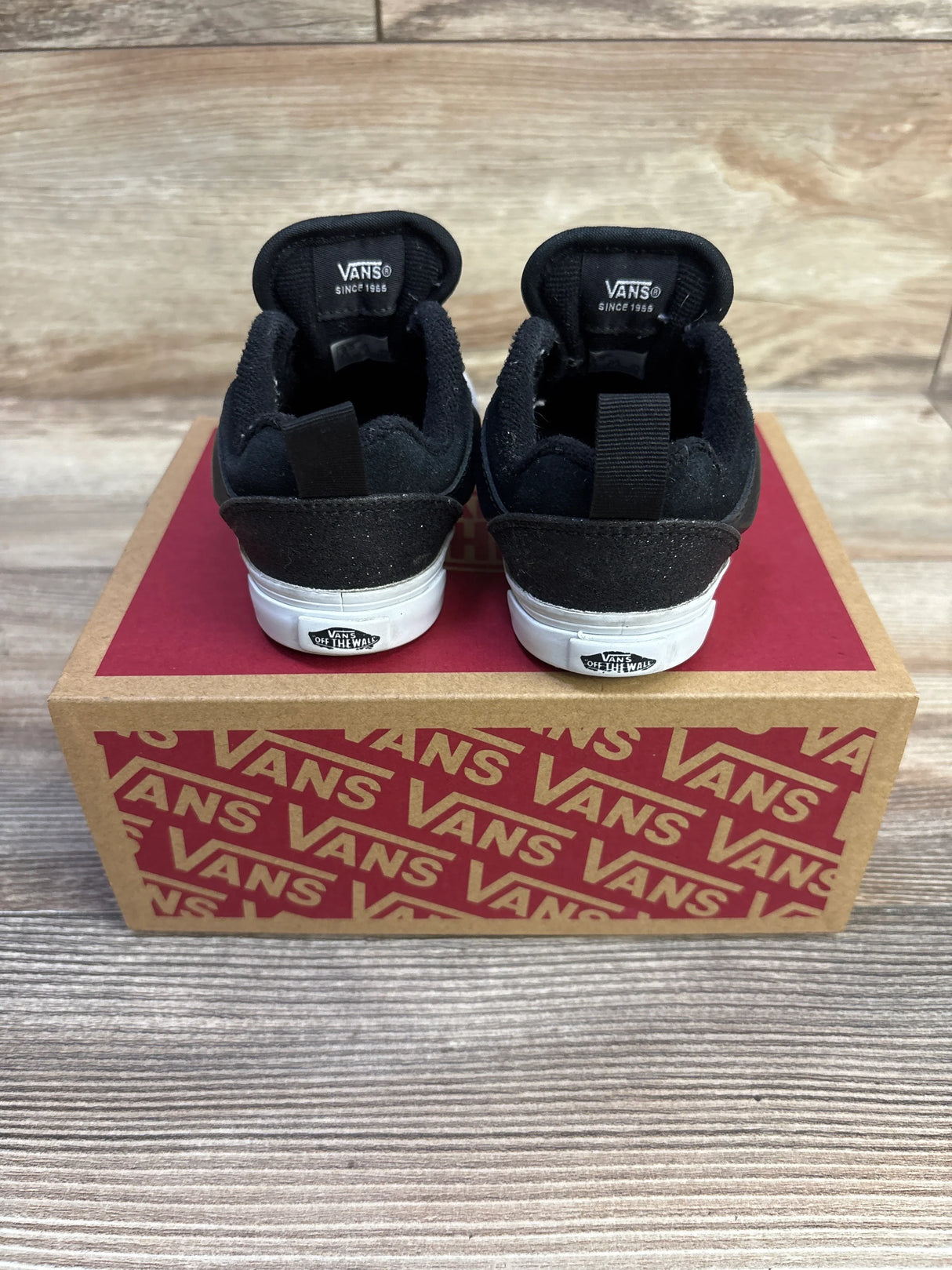 Rear view of Vans Knu Skool Dazzled black sneakers size 6C showing white rubber heels with Vans Off The Wall logo on a Vans shoebox