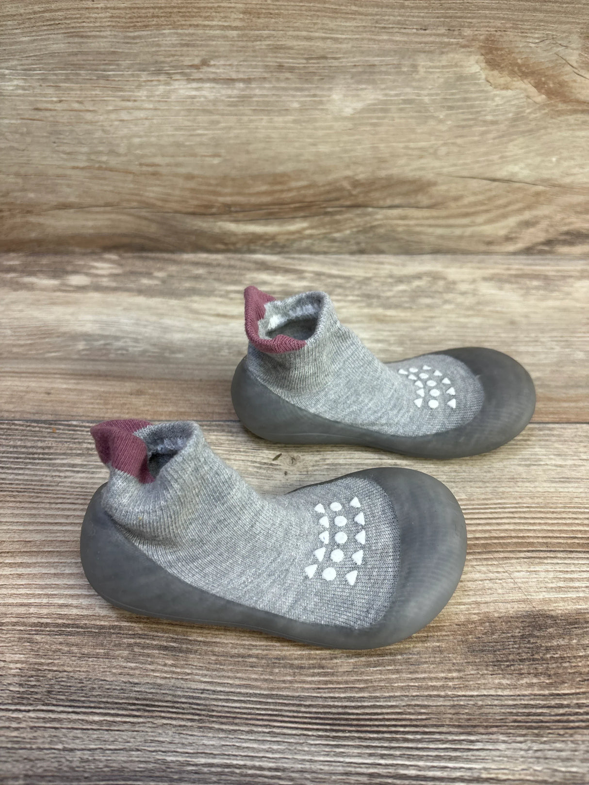 Top-down view of Bearbay grey sock shoes (size 7/8C) showing rubber soles, white non-slip grip dots, and ankle sock cuffs on a wooden background