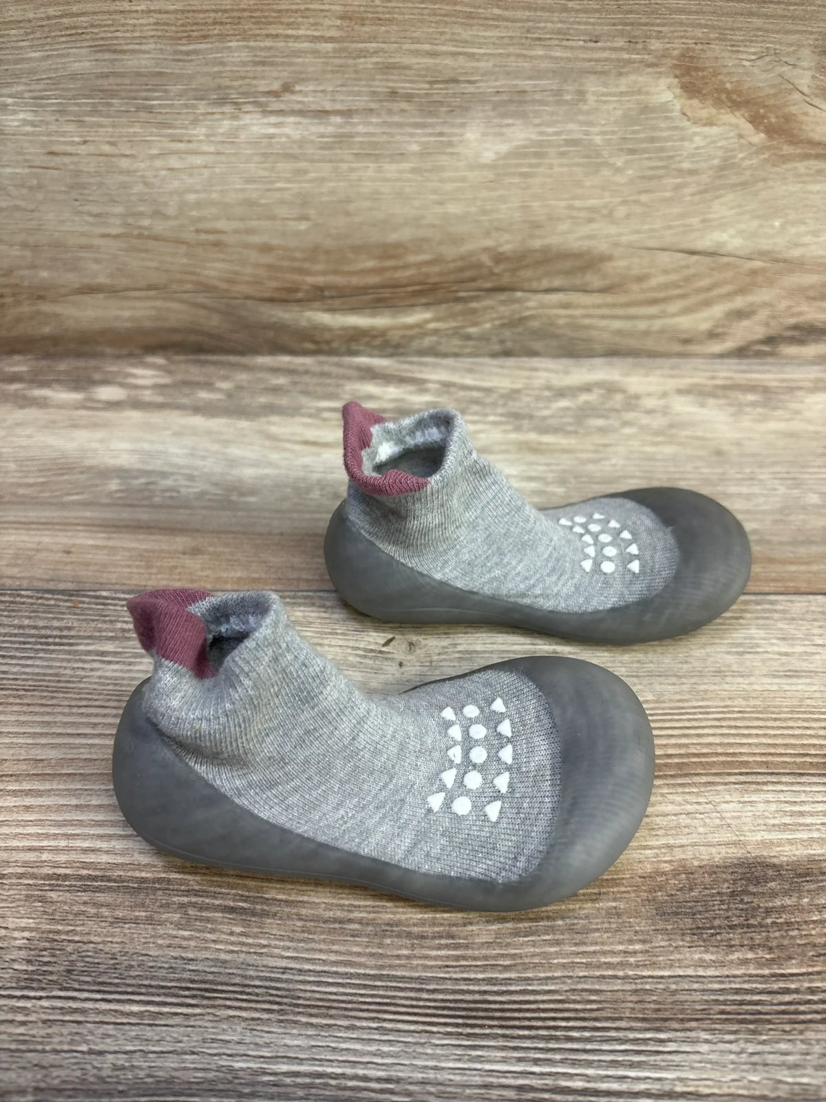Top-down view of Bearbay grey sock shoes (size 7/8C) showing rubber soles, white non-slip grip dots, and ankle sock cuffs on a wooden background