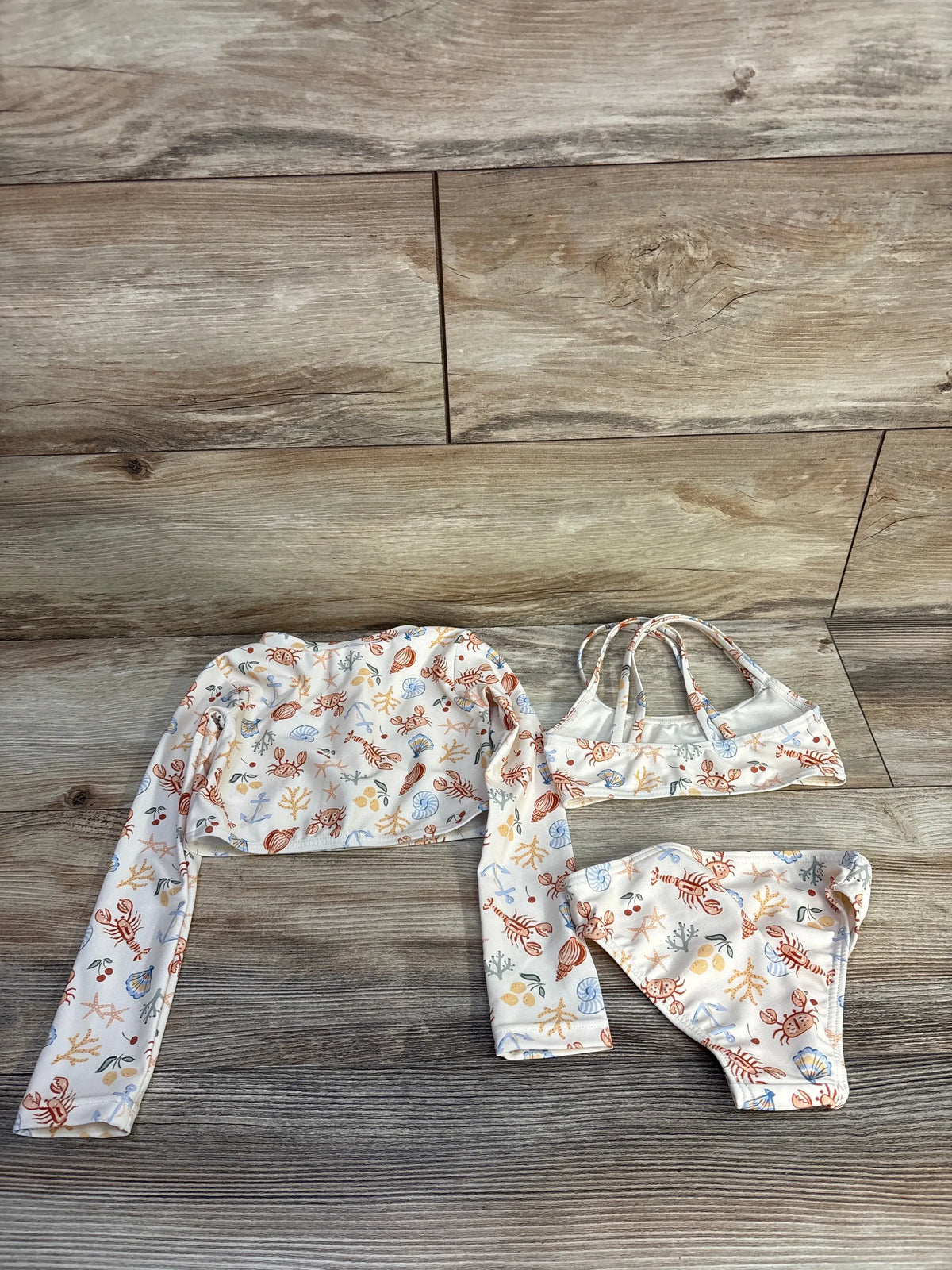 Top view of Rylee + Cru 3-piece cropped rashguard set with nautical ivory print, top, bottoms, and long-sleeve rashguard
