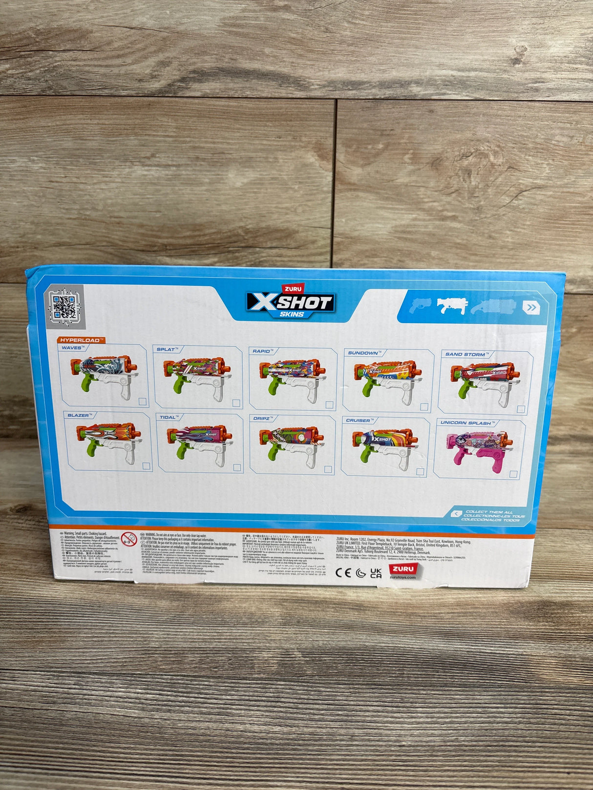 Back of Zuru X-Shot Skins toy water blaster box showing models on wood floor