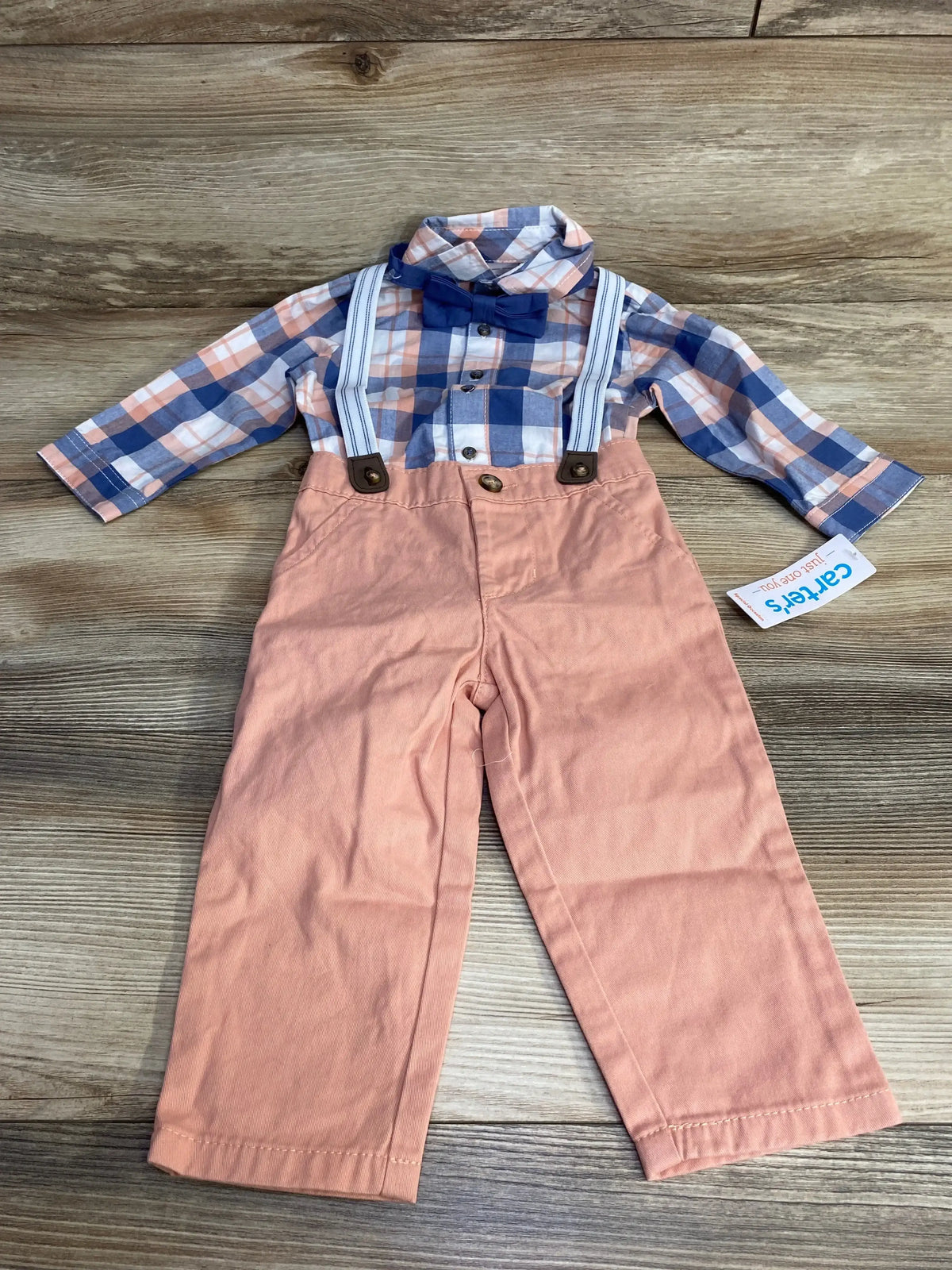 Flat lay of NEW Just One You 4pc Plaid Button-Up Suspender Set Blue sz 12m showcasing plaid shirt blue bow tie and peach suspender pants with hangtag