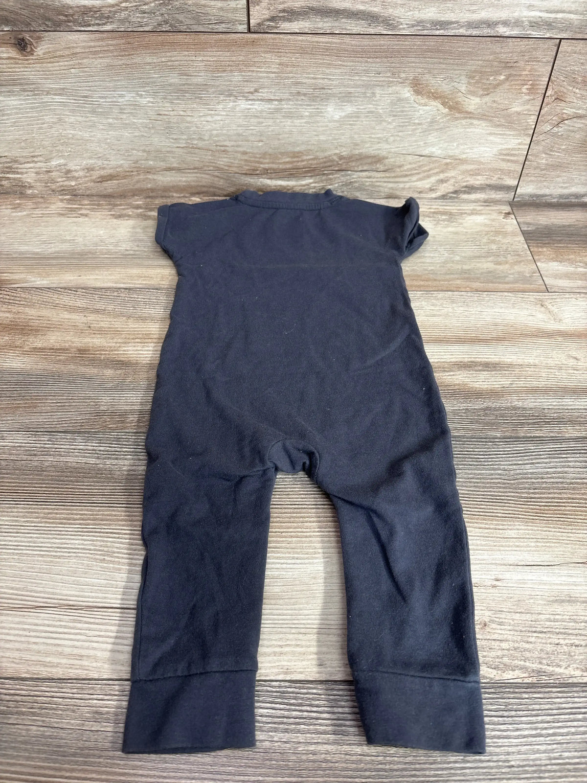 Back flat-lay of grey Cat & Jack Loved baby jumpsuit 6-9 months showing short sleeves and long legs with folded cuffs on wood background