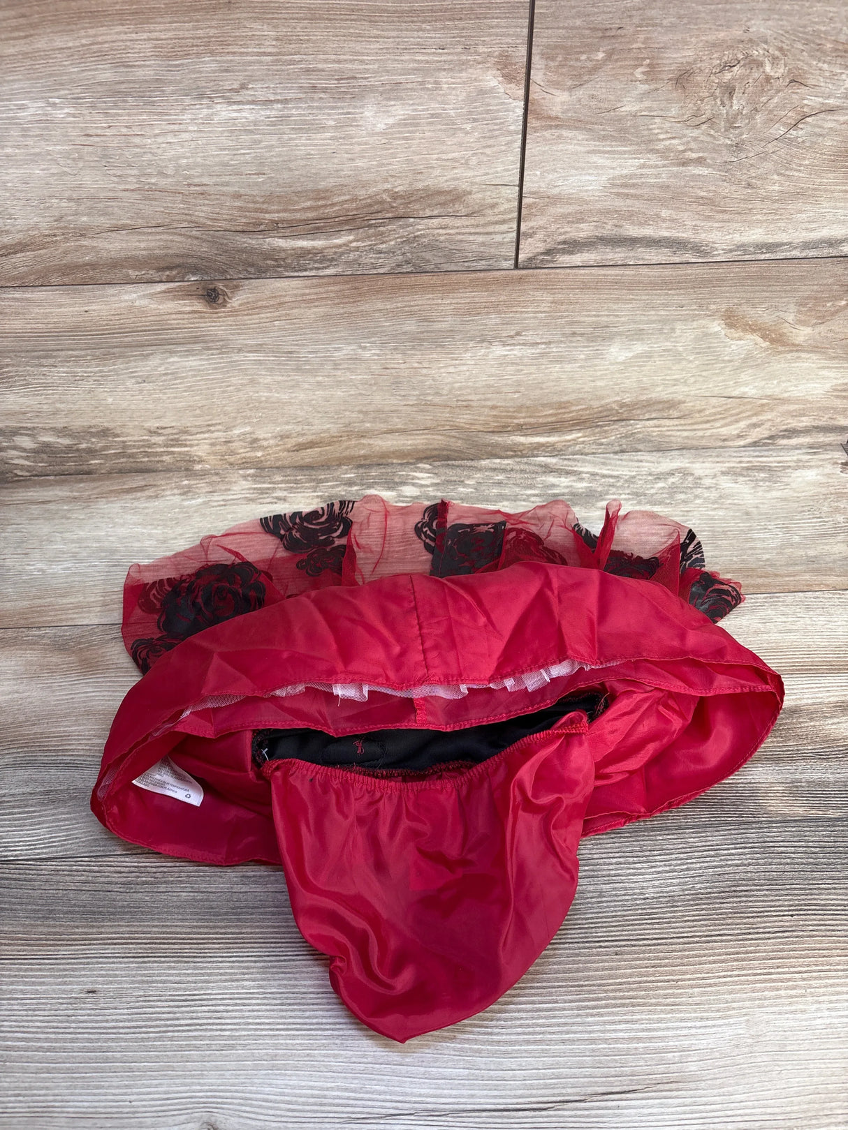 Red and black floral mesh petticoat skirt laid flat on wooden floor background