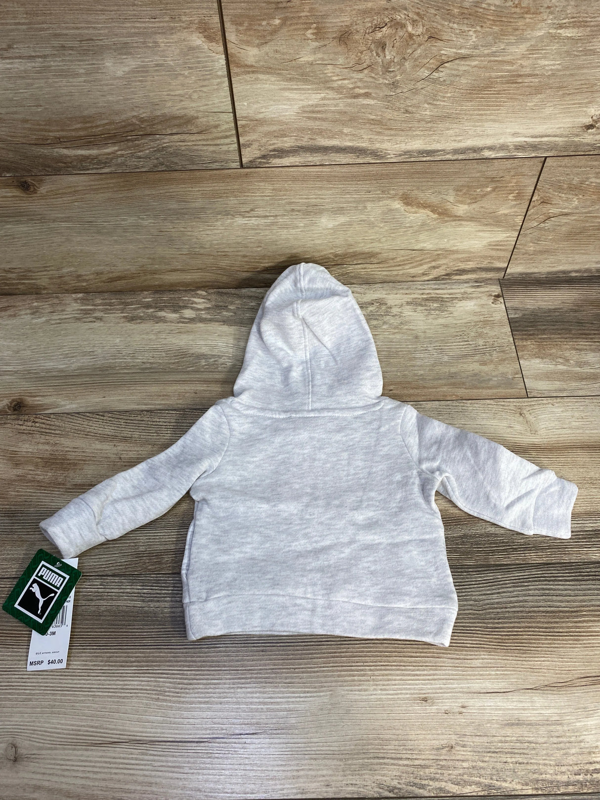 Light gray toddler Puma hoodie with tag on wood floor background