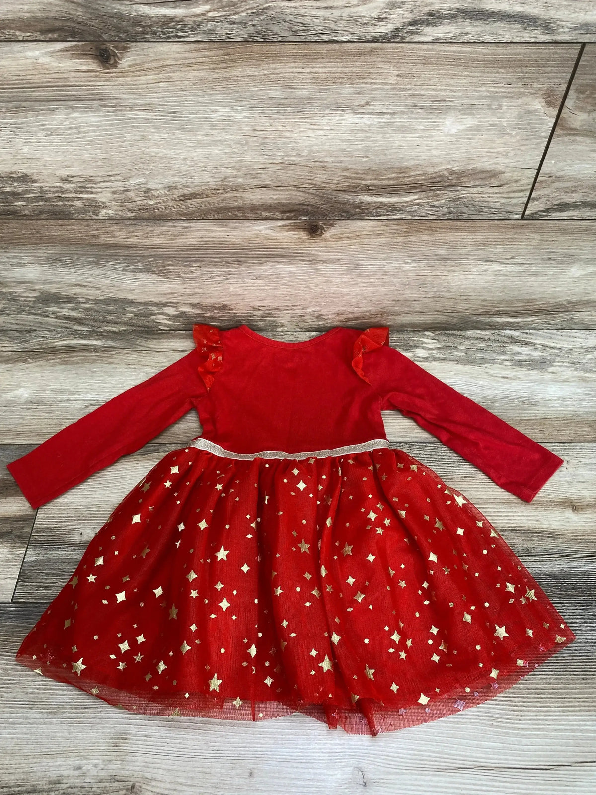 Flat lay of Cat and Jack ruffle tulle dress in red size 2T showcasing long sleeves and gold star print tulle skirt on wood plank floor