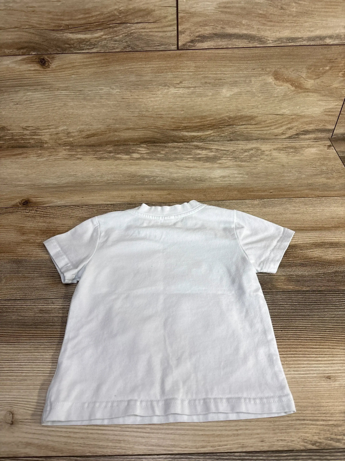 White short sleeve toddler t-shirt laid flat on wood background