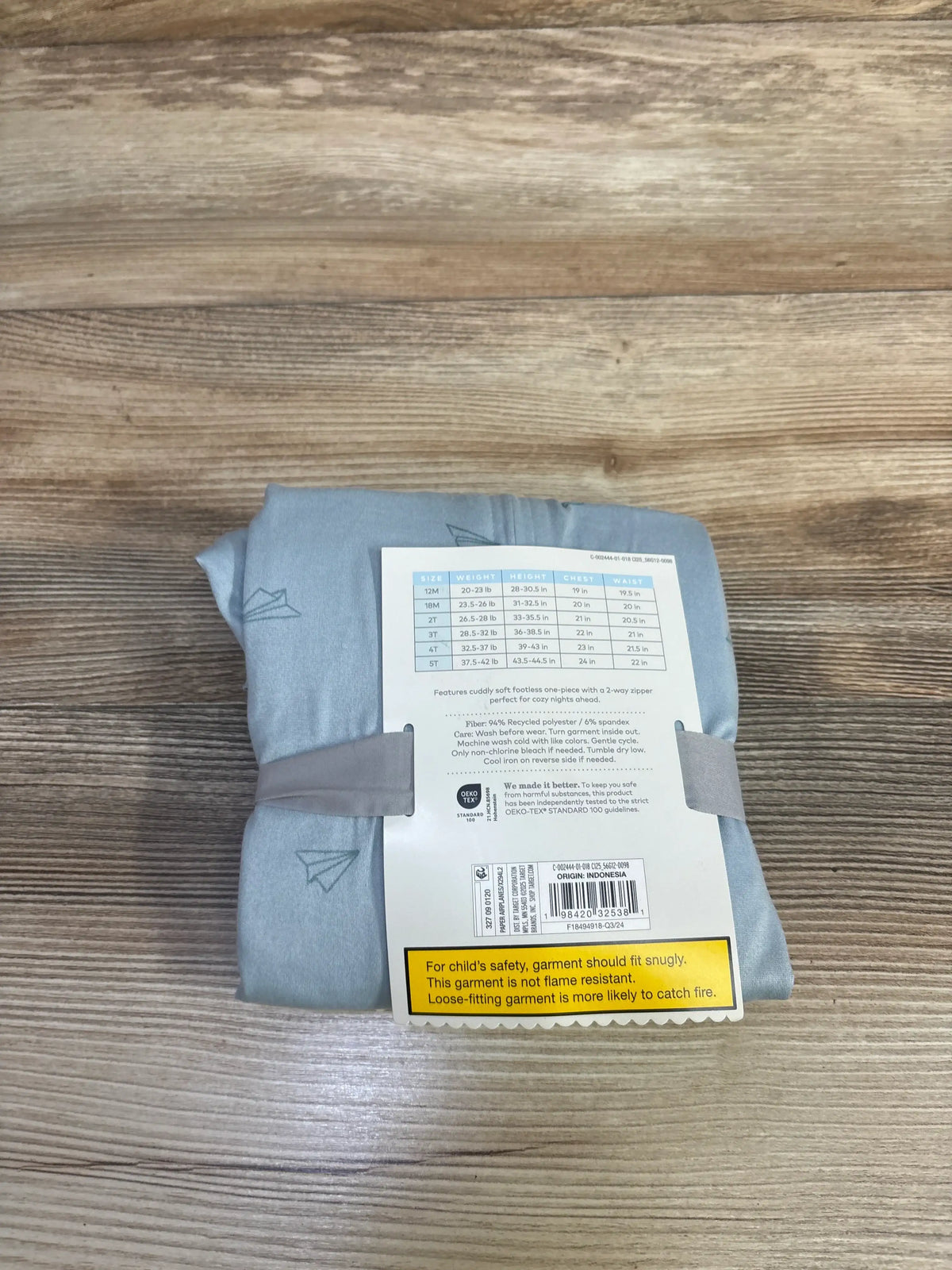 Top view of blue Cloud Island footless sleeper in size 5T showcasing paper airplane print and zip closure on folded garment