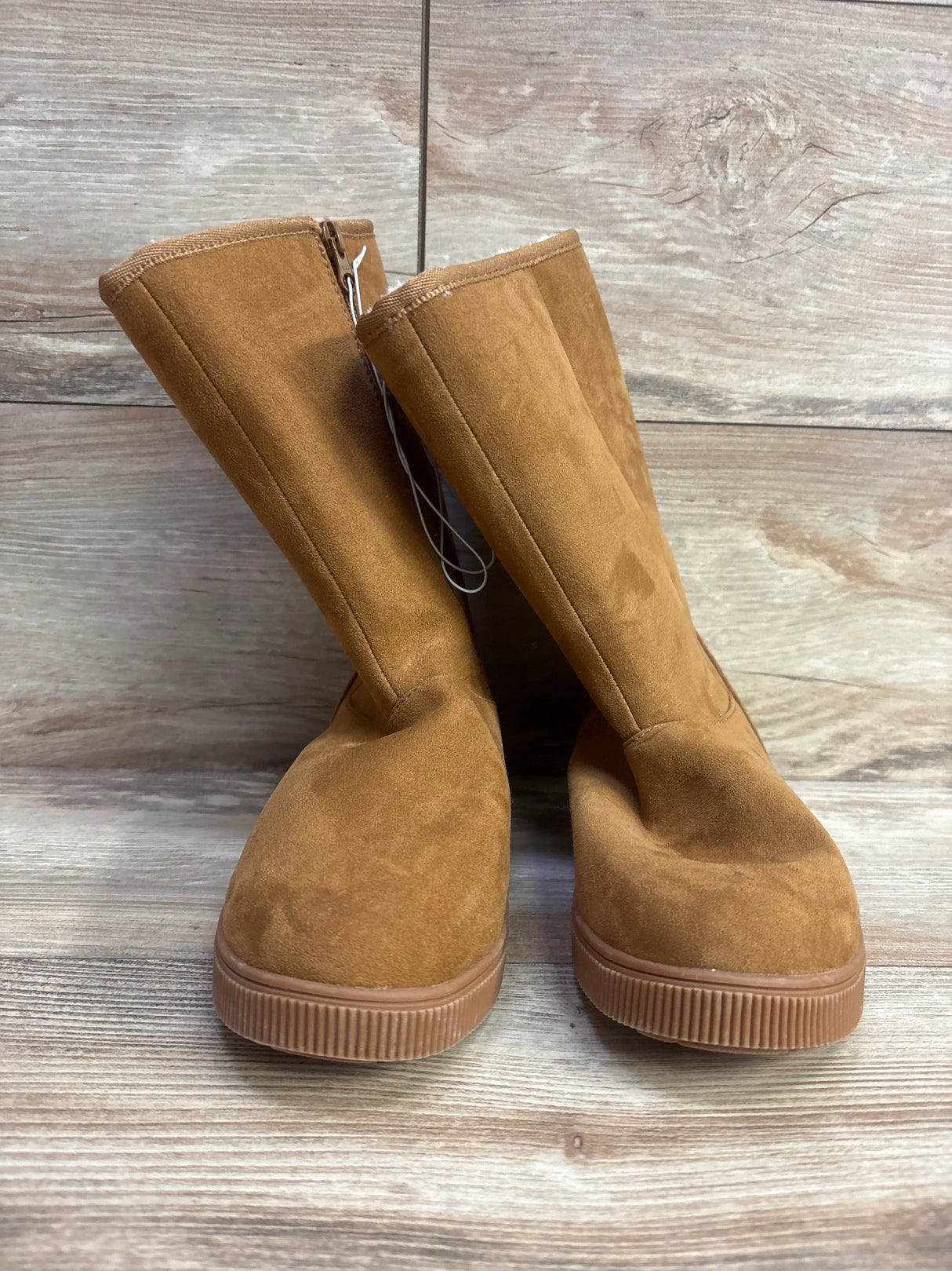 Tan suede kids boots with side zippers on wood floor, children's footwear resale