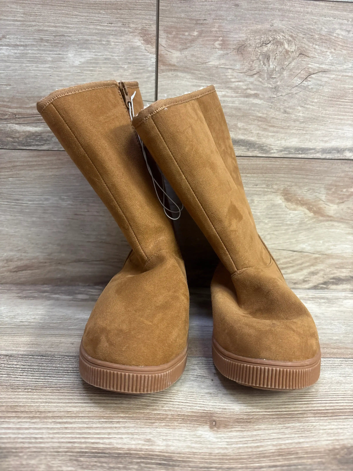 Tan suede kids boots with side zippers on wood floor, children's footwear resale