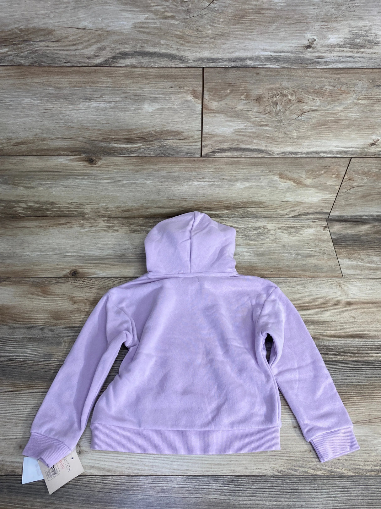 Back view of a light purple kids' hooded sweatshirt on wood floor