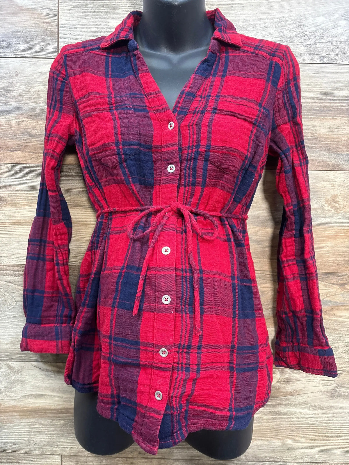 Red and navy plaid maternity shirt with front tie and button-down design on mannequin