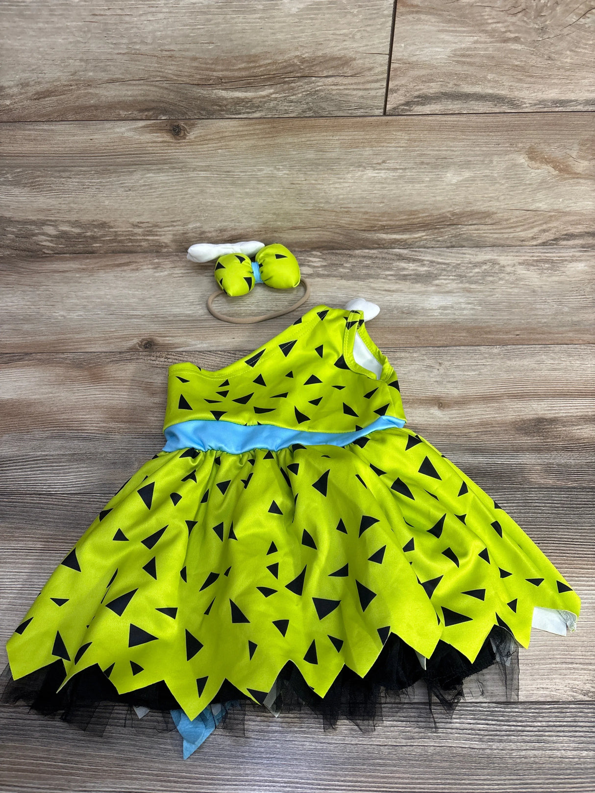 Bright green toddler dress with black triangles, blue waistband, and matching headband for kids' costumes.