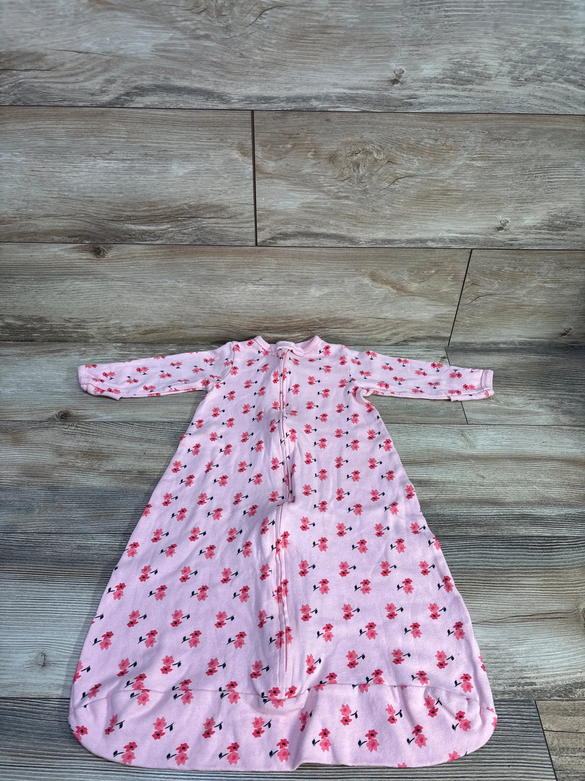 Front view of Touched By Nature pink floral sleep sack with long sleeves and full-length zipper on a wood-look floor